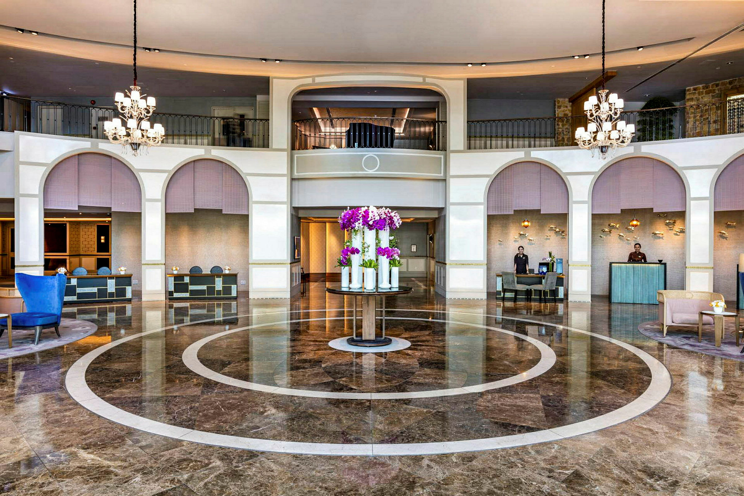 Hotellobby med marmorgolv, reception och skulptur med blommor. (AI-genererad text)