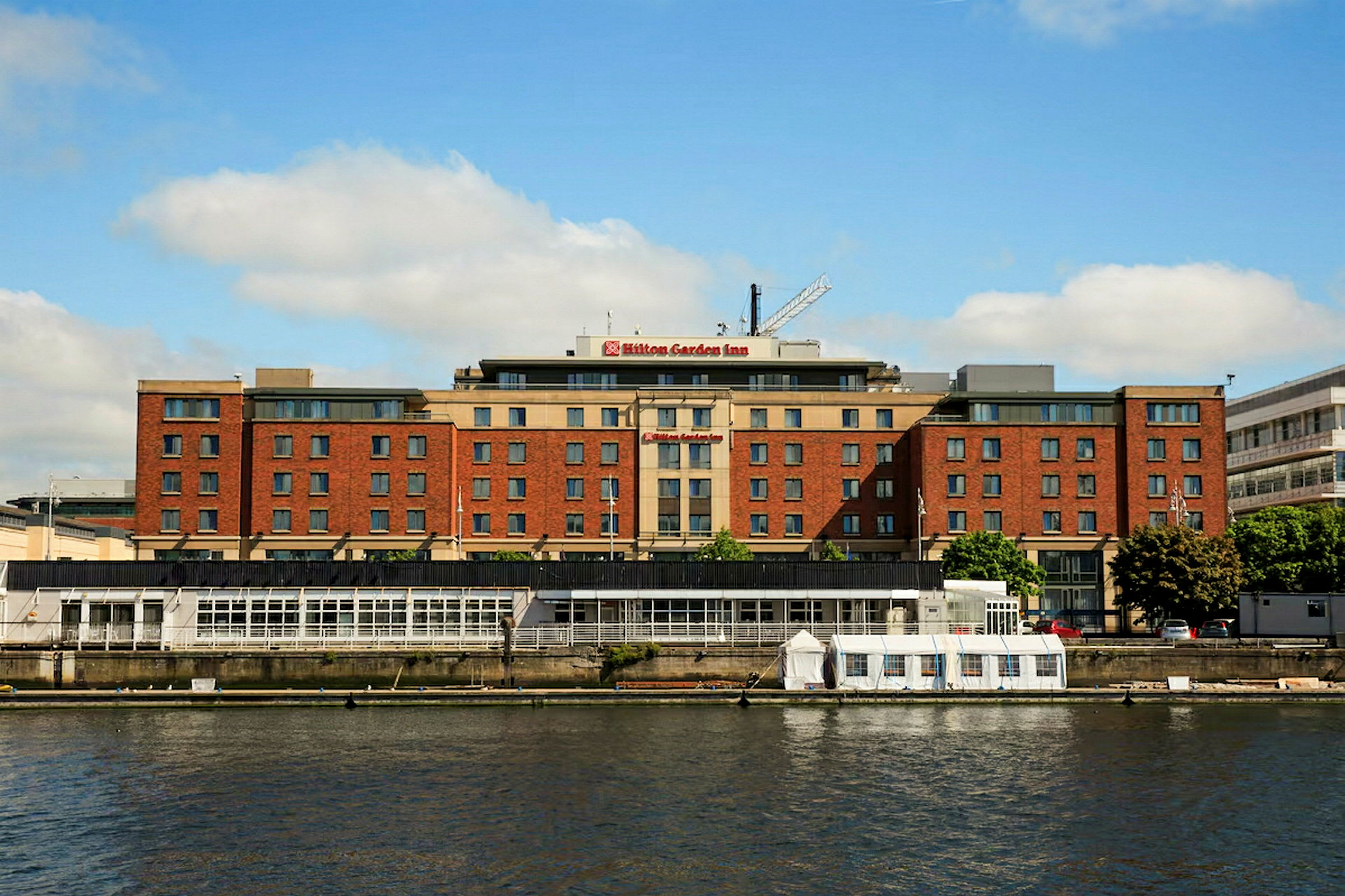 En byggnad märkt som Hilton Garden Inn vid en vattensamling. (AI-genererad text)