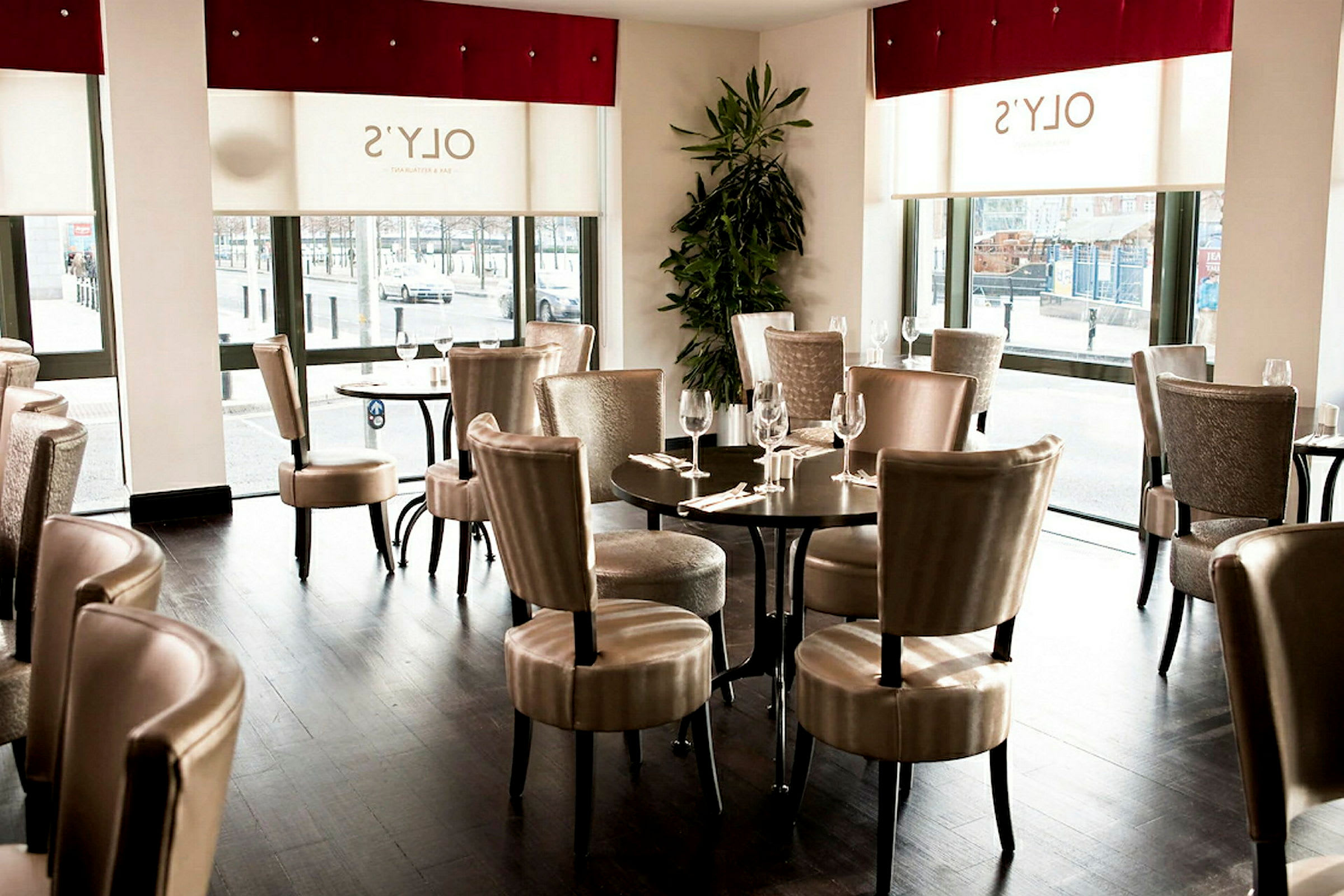 Inomhus i en restaurang med bord och stolar samt stora fönster. (AI-genererad text)