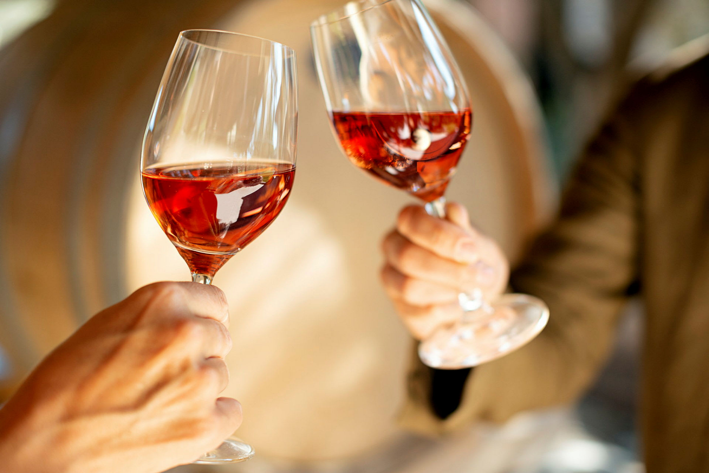 Två glas med rosévin hålls upp. (AI-genererad text)