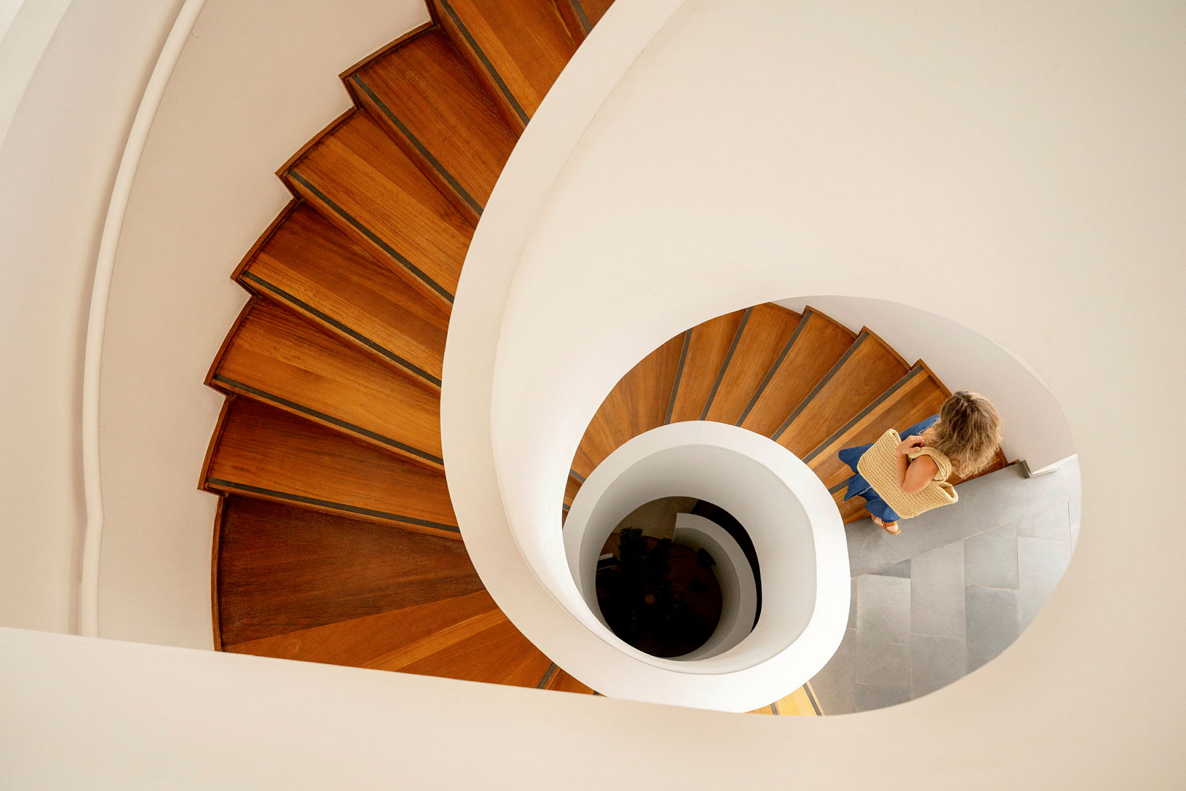 En person går nedför en spiraltrappa av trä. (AI-genererad text)