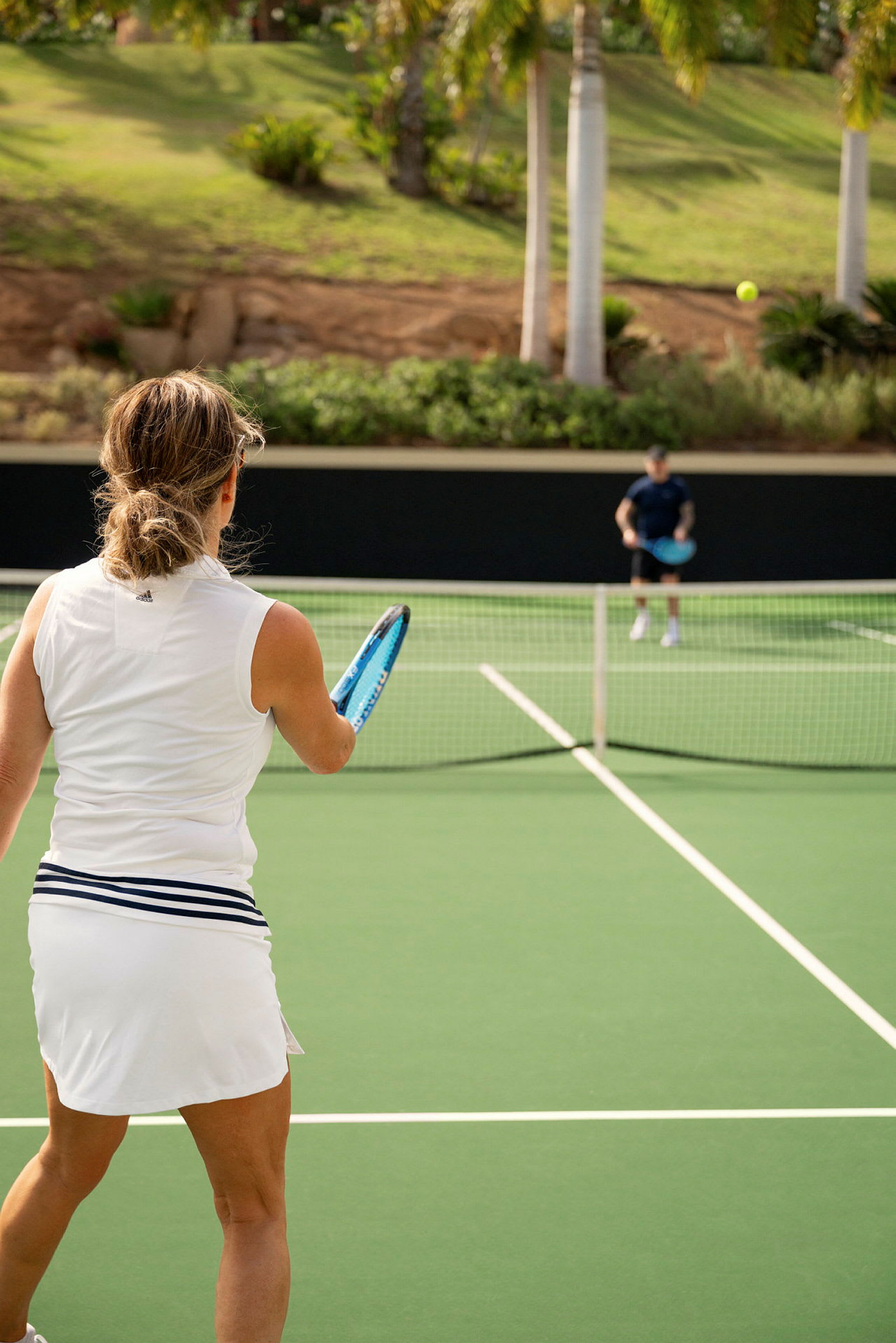 En kvinna spelar tennis på en utomhusbana. (AI-genererad text)