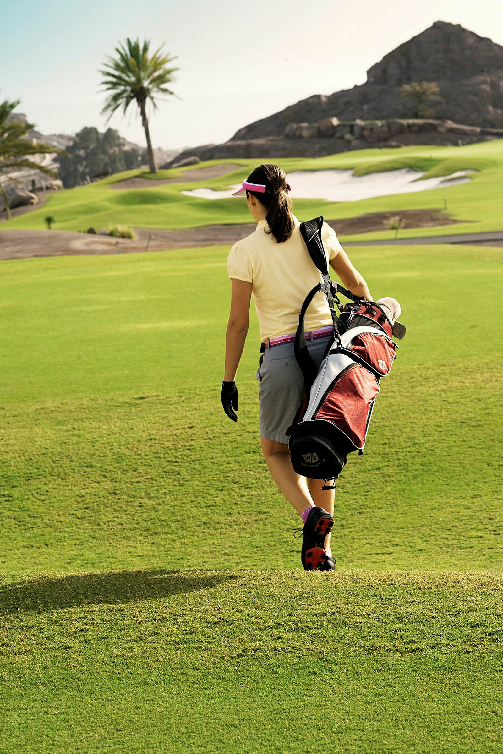 En person går på en golfbana med en golfbag på axeln. (AI-genererad text)