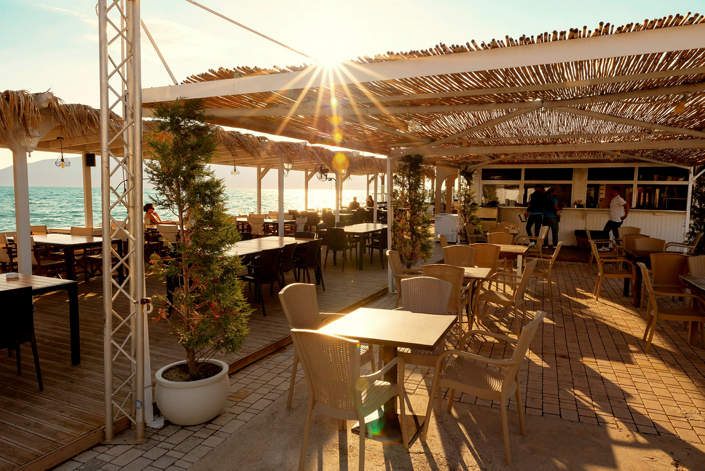 Strandnära restaurang med tak och uteservering. (AI-genererad text)
