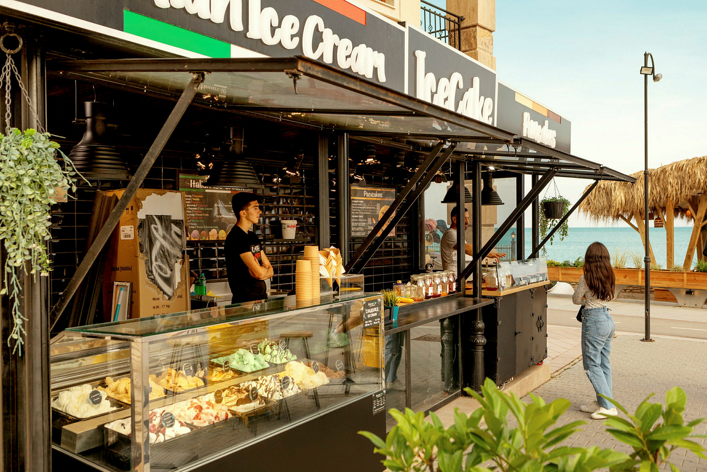 En glasskiosk vid stranden med olika smaker utställda. (AI-genererad text)