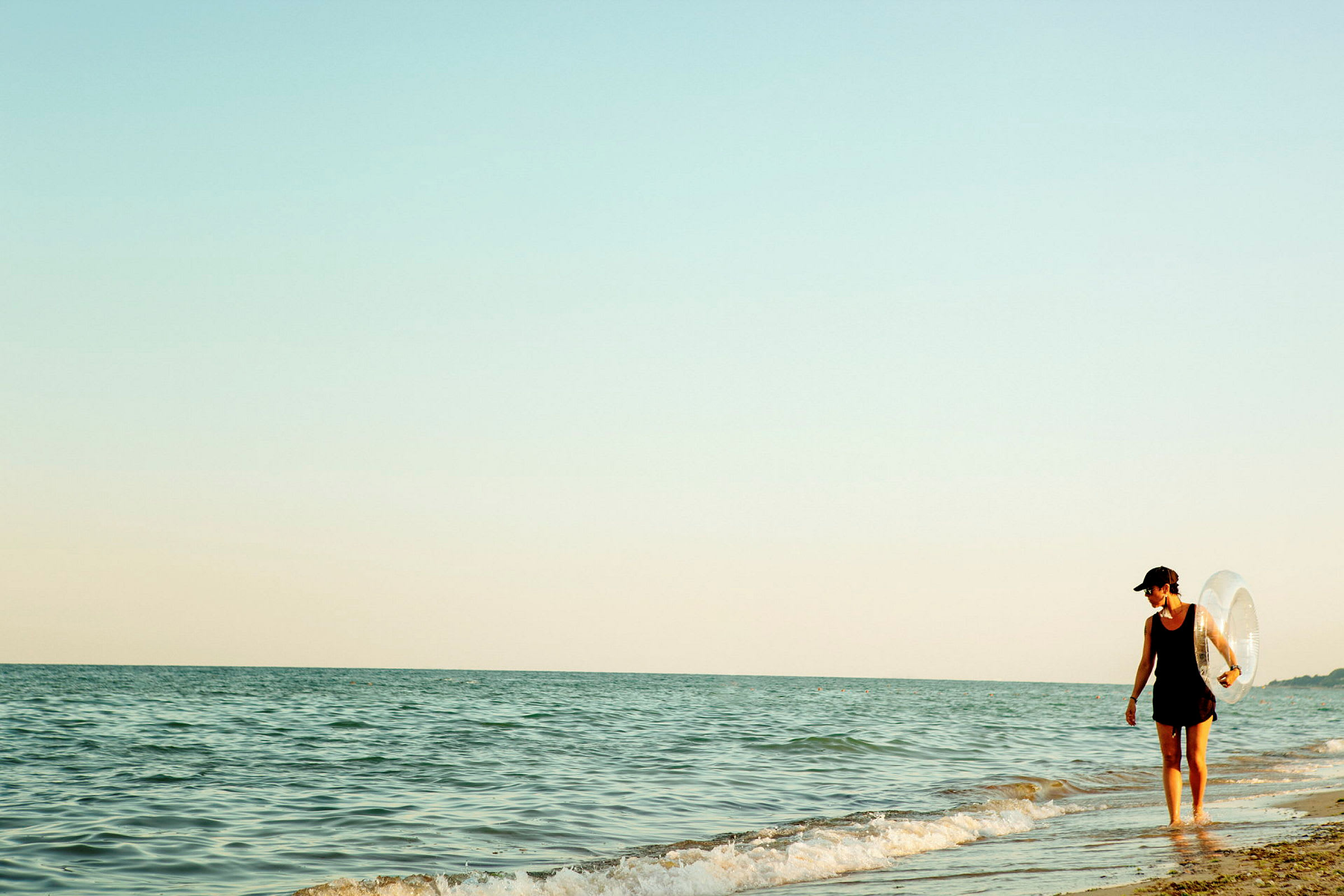 Person går längs strandkanten nära havet. (AI-genererad text)