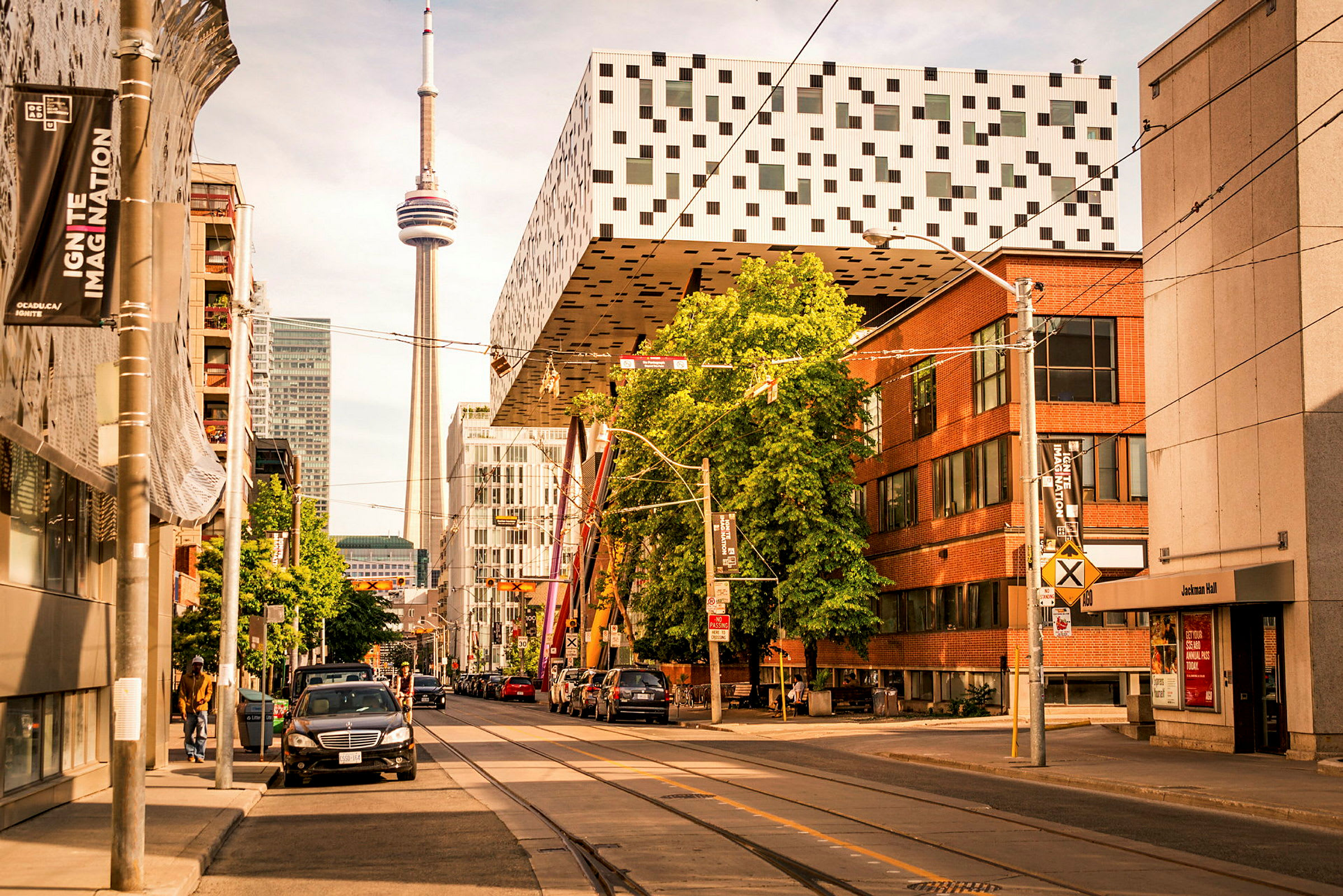 Gata med byggnader, parkering och CN Tower i bakgrunden. (AI-genererad text)
