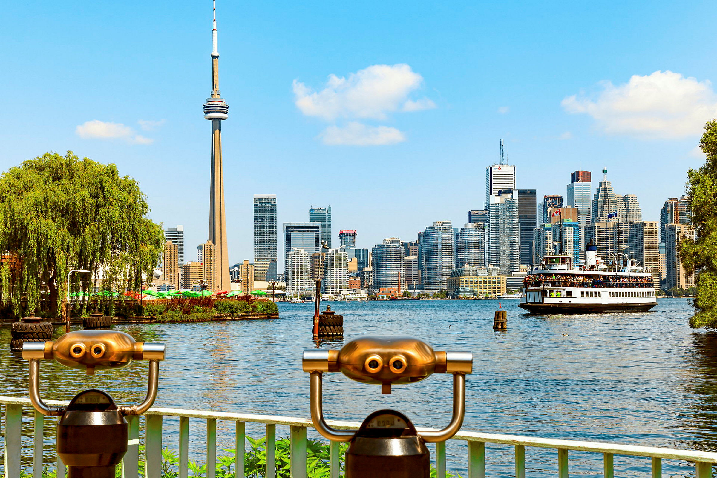 Utsikt över Torontos skyline med CN Tower och en färja på vattnet. (AI-genererad text)