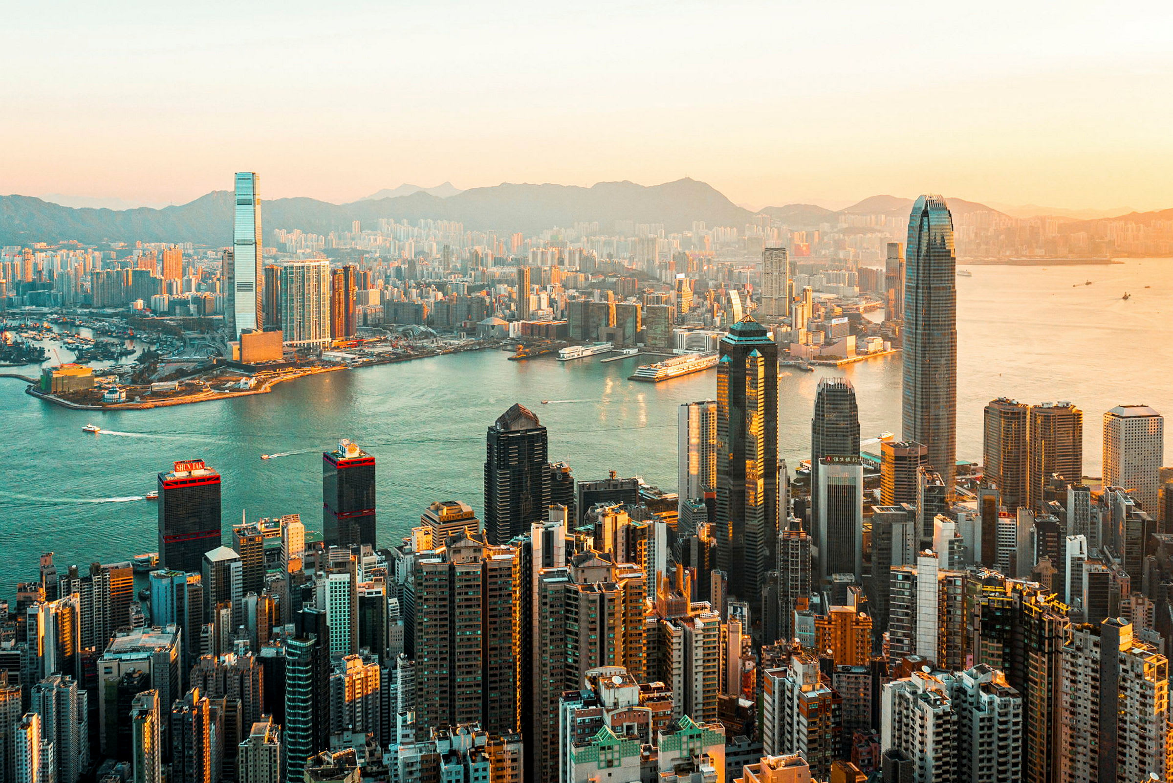 Vy över Hong Kong och dess skyskrapor vid solnedgång. (AI-genererad text)