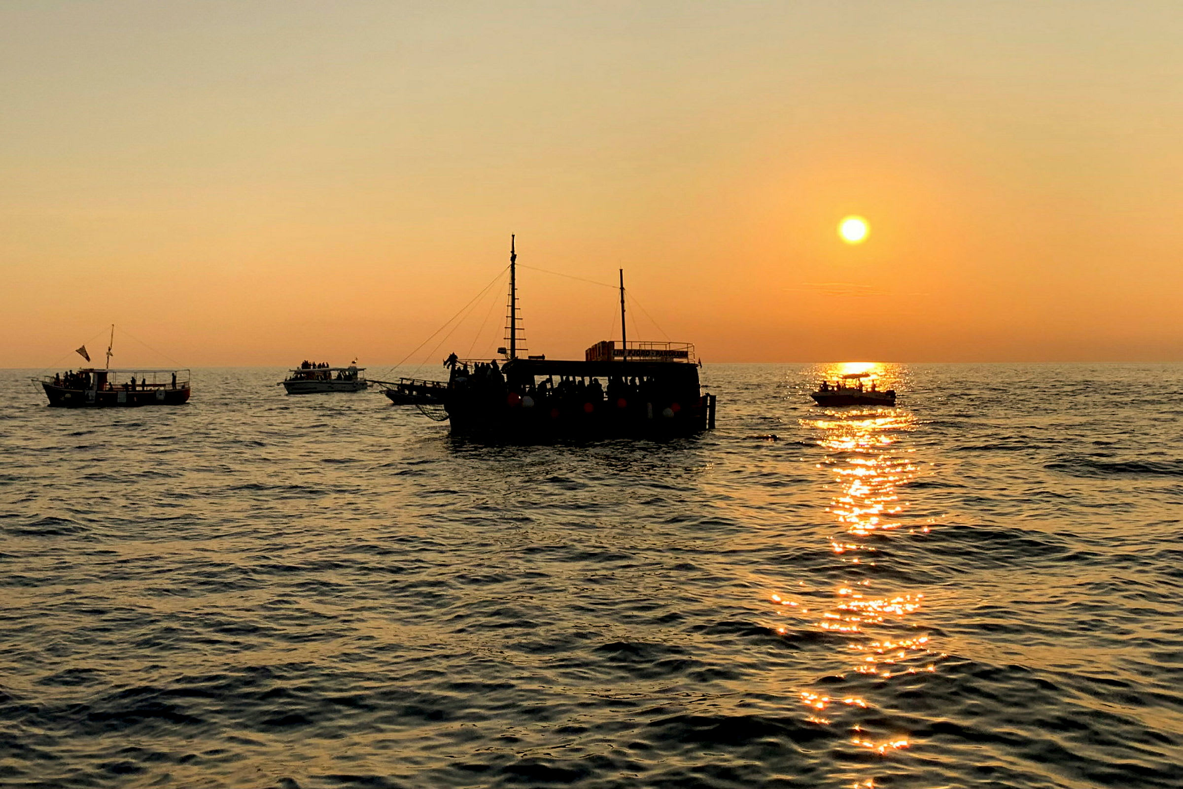 Flera båtar på havet vid solnedgången. (AI-genererad text)