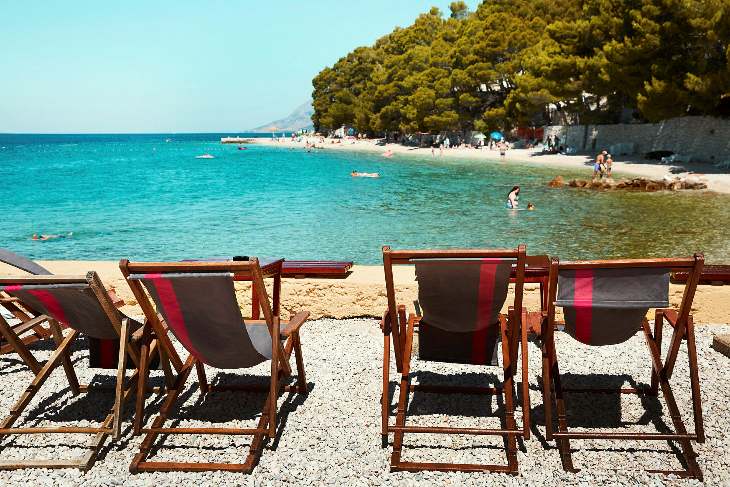 Solstolar vid en strand med klart vatten. (AI-genererad text)