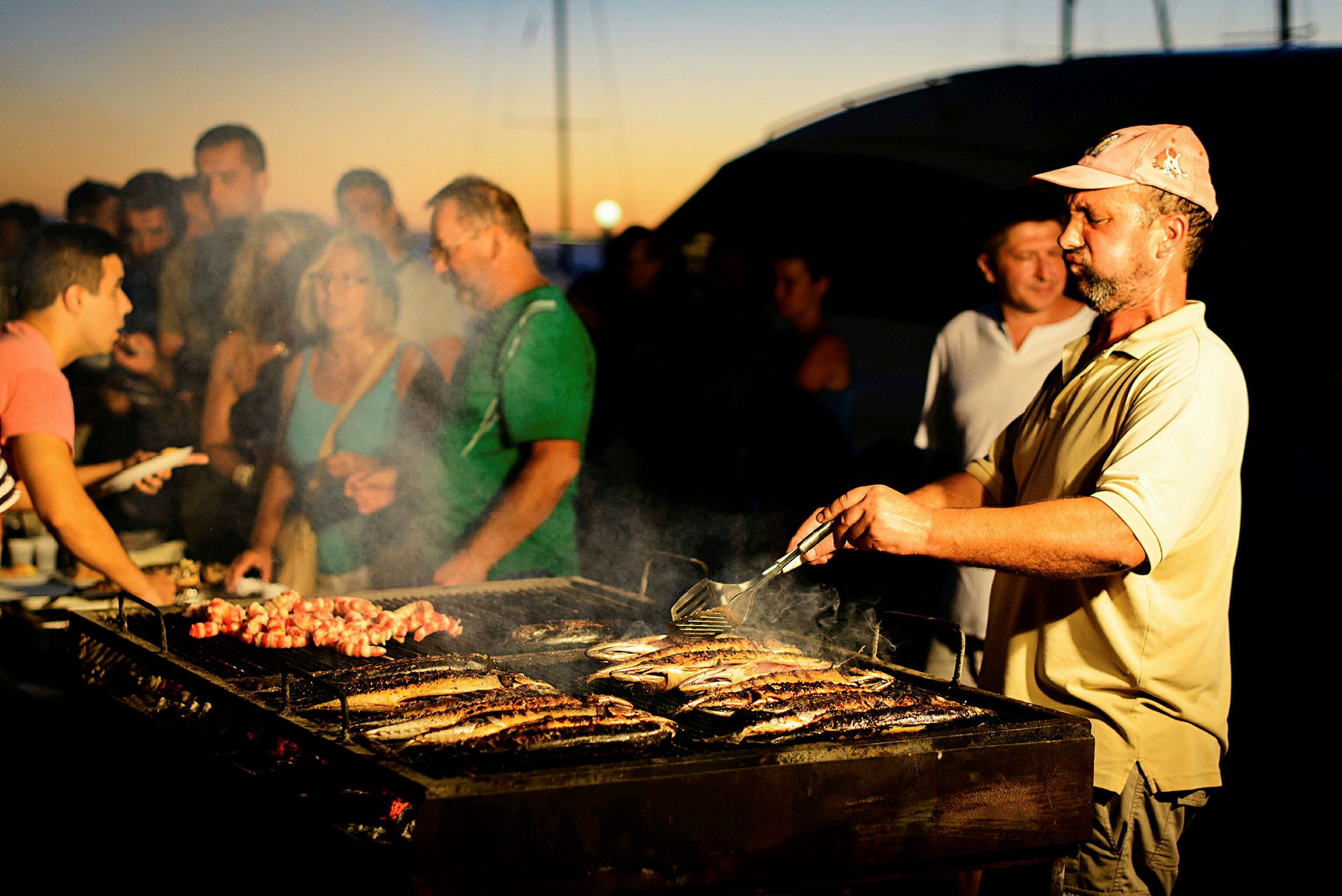 Person tillagar mat på en grill utomhus. (AI-genererad text)