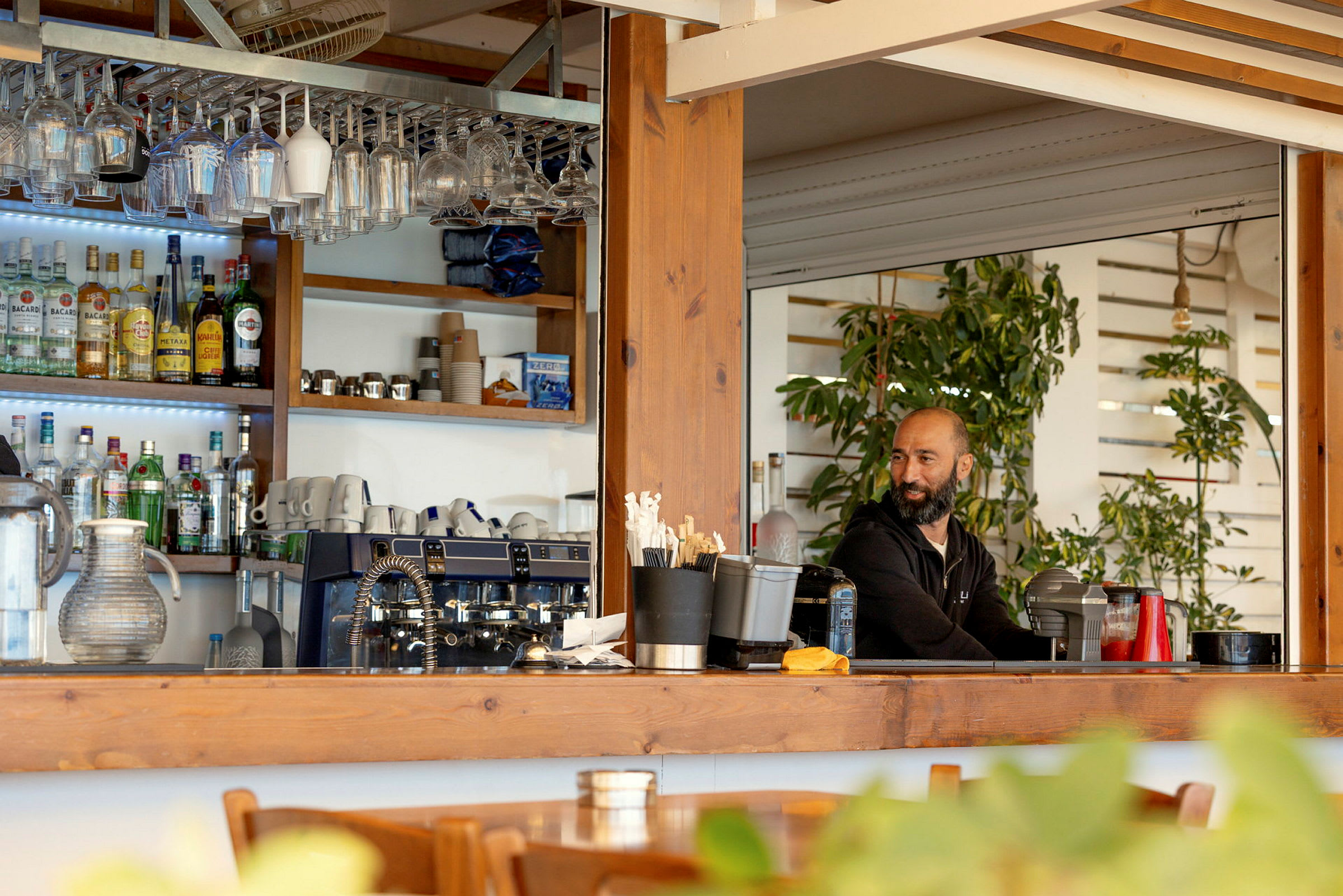 En bar med dryckeshyllor, glas och kaffemaskiner. (AI-genererad text)