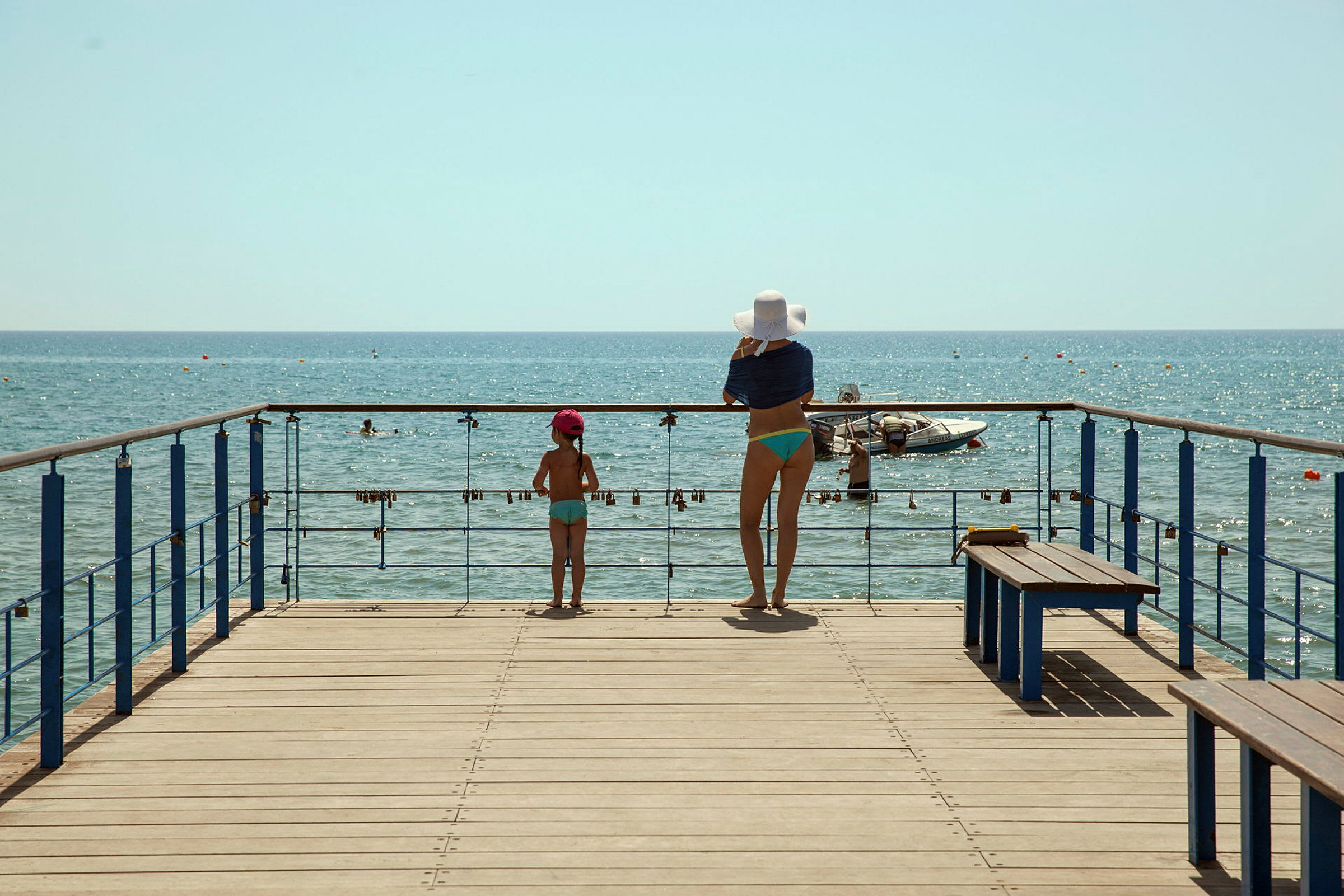 En kvinna och ett barn står på en brygga och tittar ut över havet. (AI-genererad text)