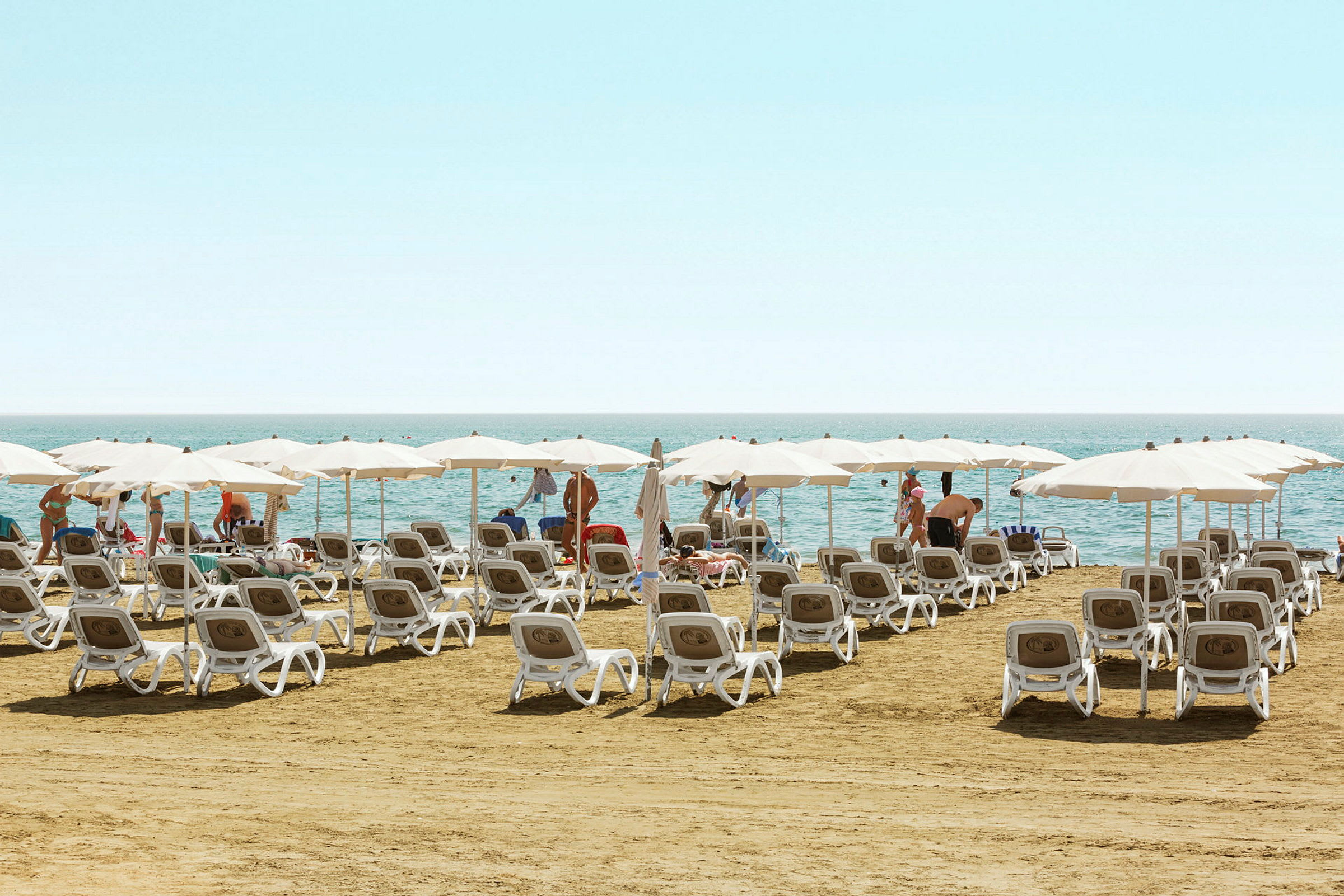 Strand med solstolar och parasoller vid havet. (AI-genererad text)