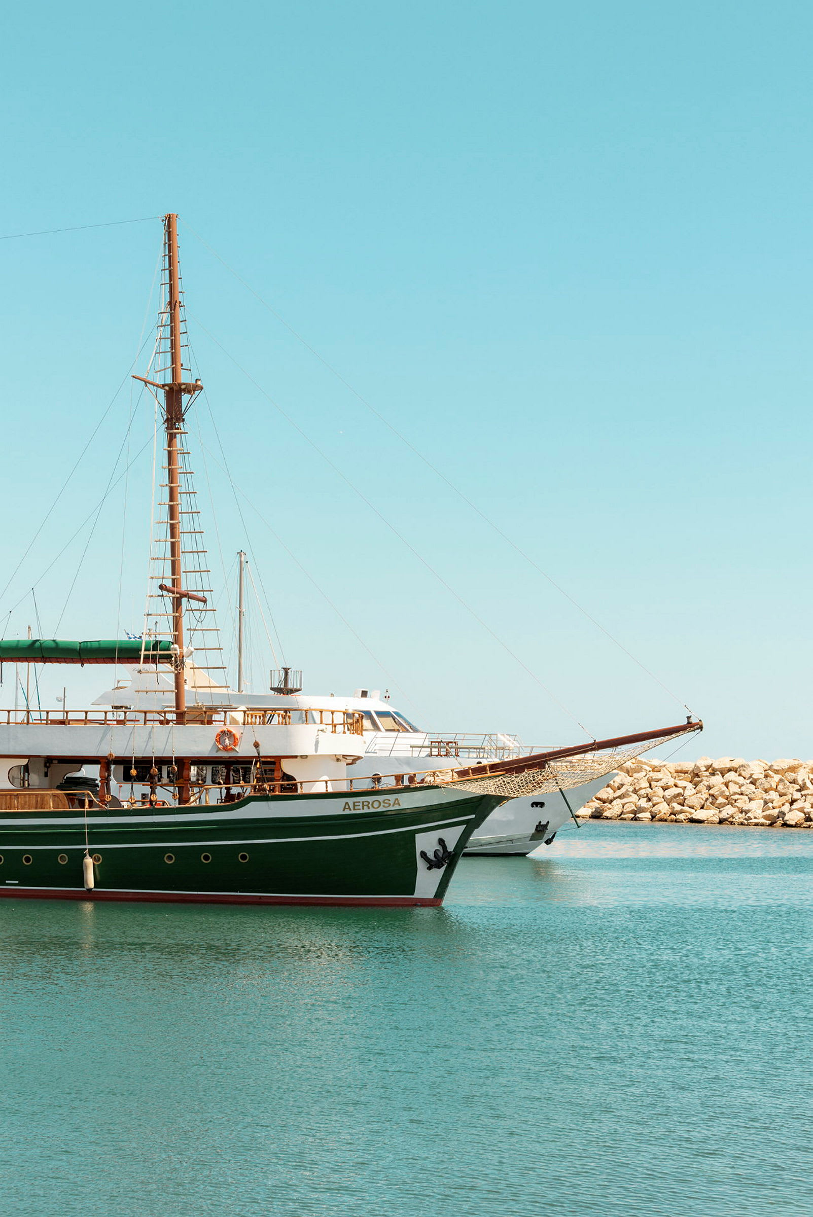 En segelbåt och en motorbåt ligger förtöjda vid en kaj. (AI-genererad text)