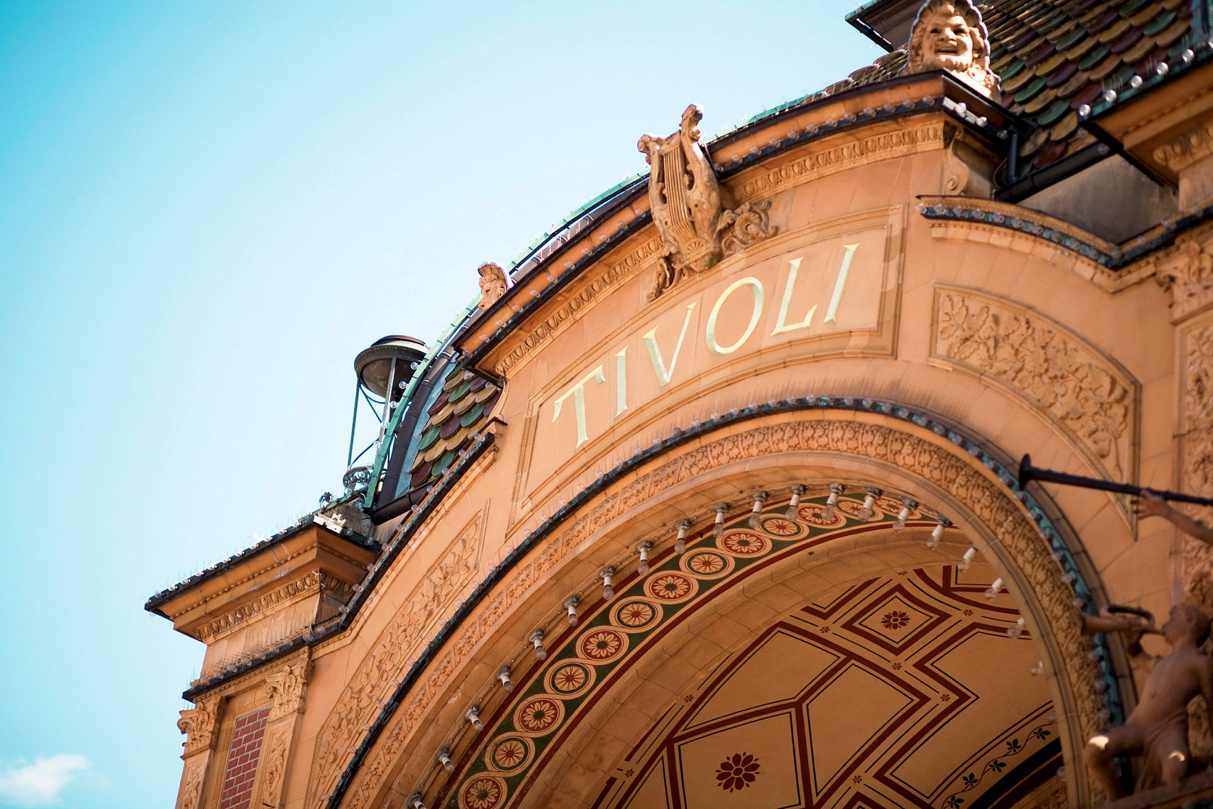 Dekorativt valv med texten 'Tivoli' på en historisk byggnad. (AI-genererad text)