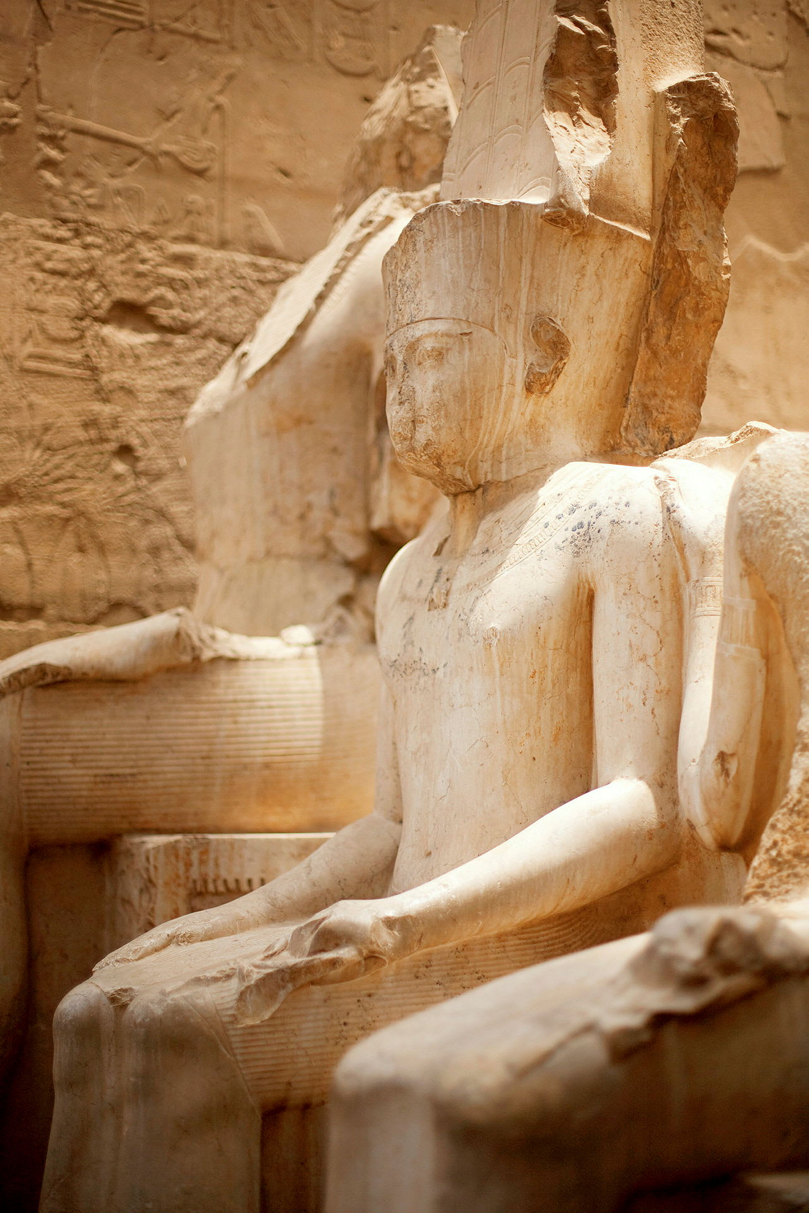 En gammal egyptisk staty av en sittande person. (AI-genererad text)