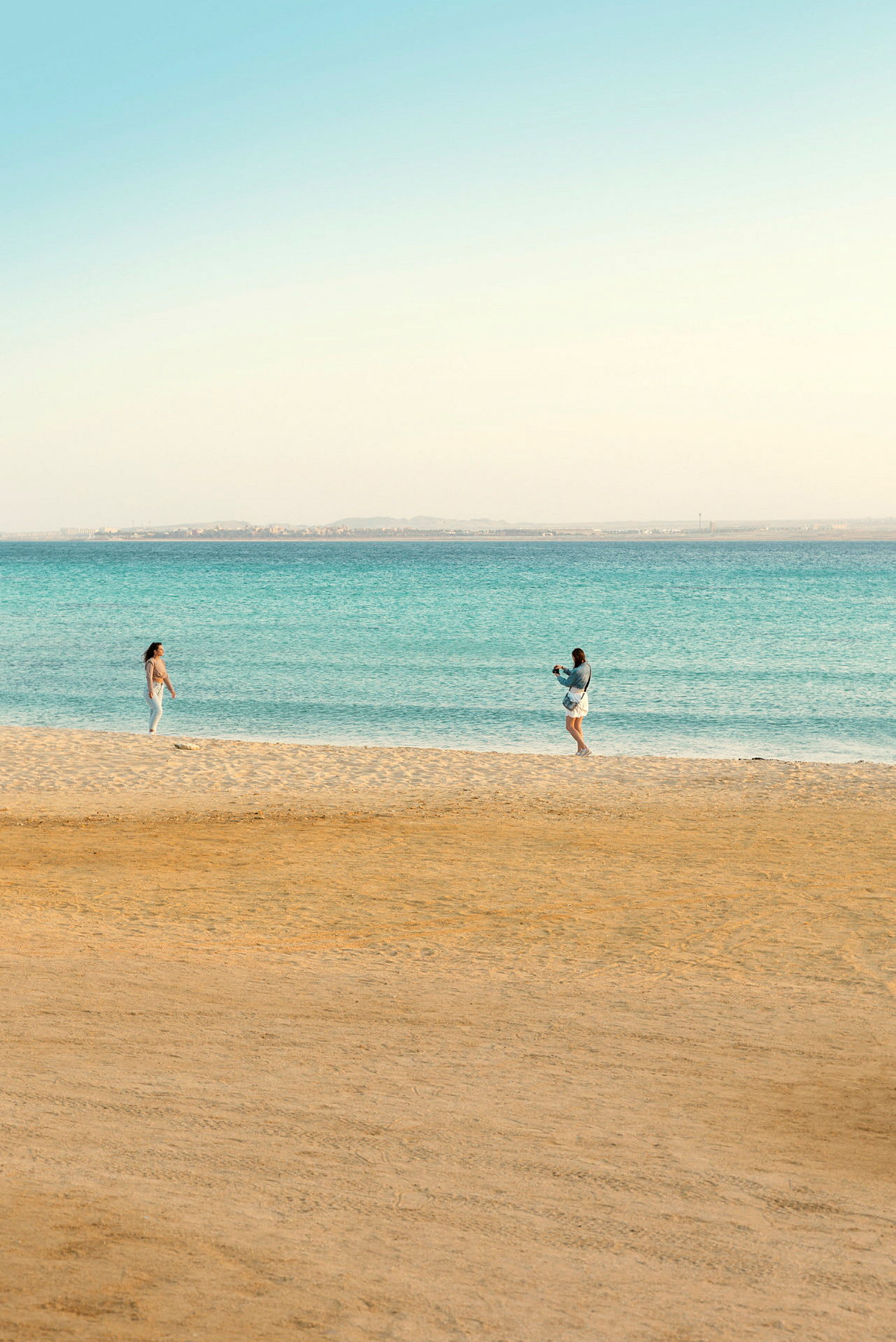 Två personer på en sandstrand nära havet. (AI-genererad text)