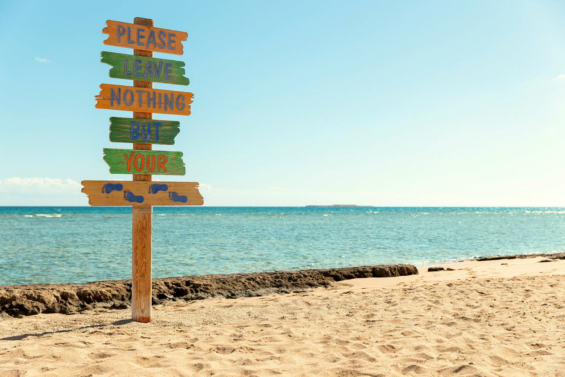 Skylt på strand med text uppmanande att inte lämna kvar skräp. (AI-genererad text)