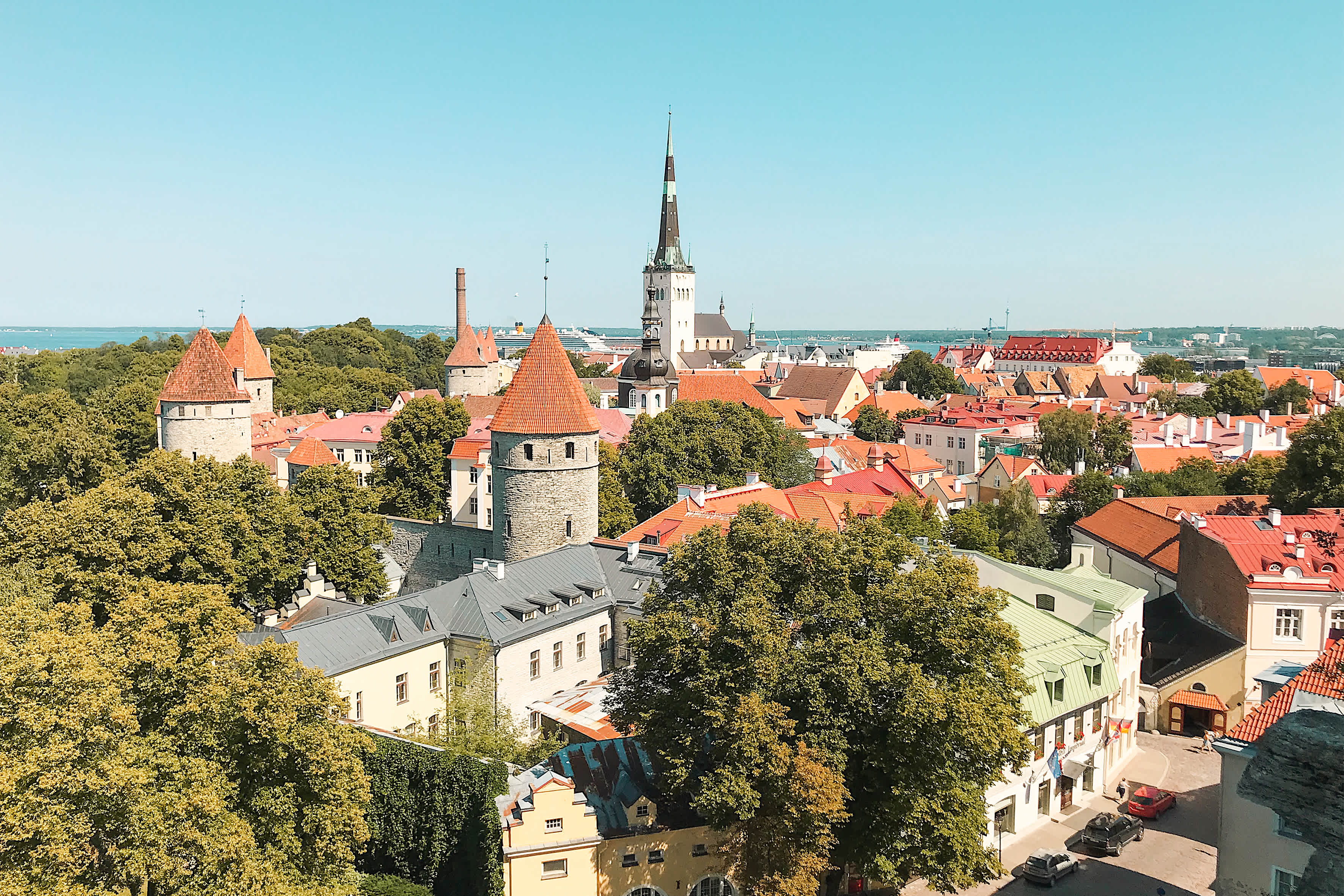 Vy över en stad med gamla byggnader, kyrktorn och träd. (AI-genererad text)