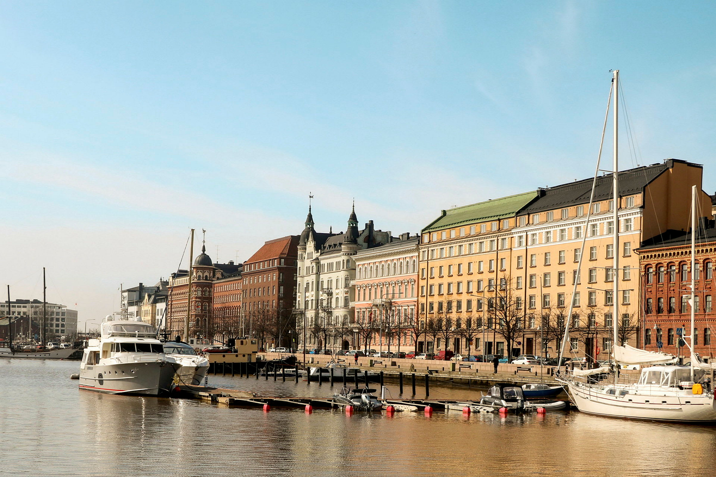 En bild av en stad som vetter mot en hamn med båtar och byggnader. (AI-genererad text)