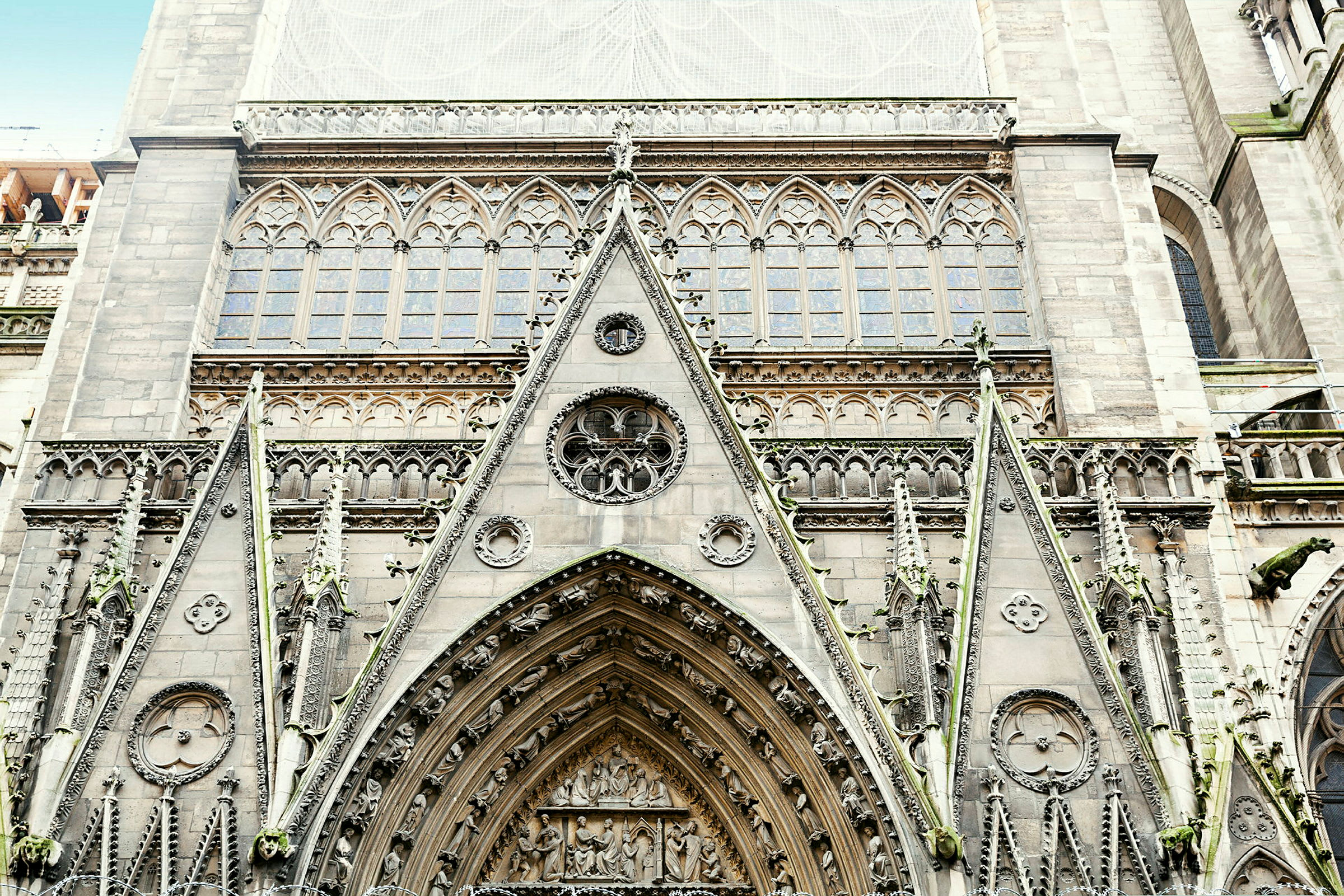 Detaljerad fasad av en gotisk kyrkobyggnad med ornamenterade bågar och fönster. (AI-genererad text)