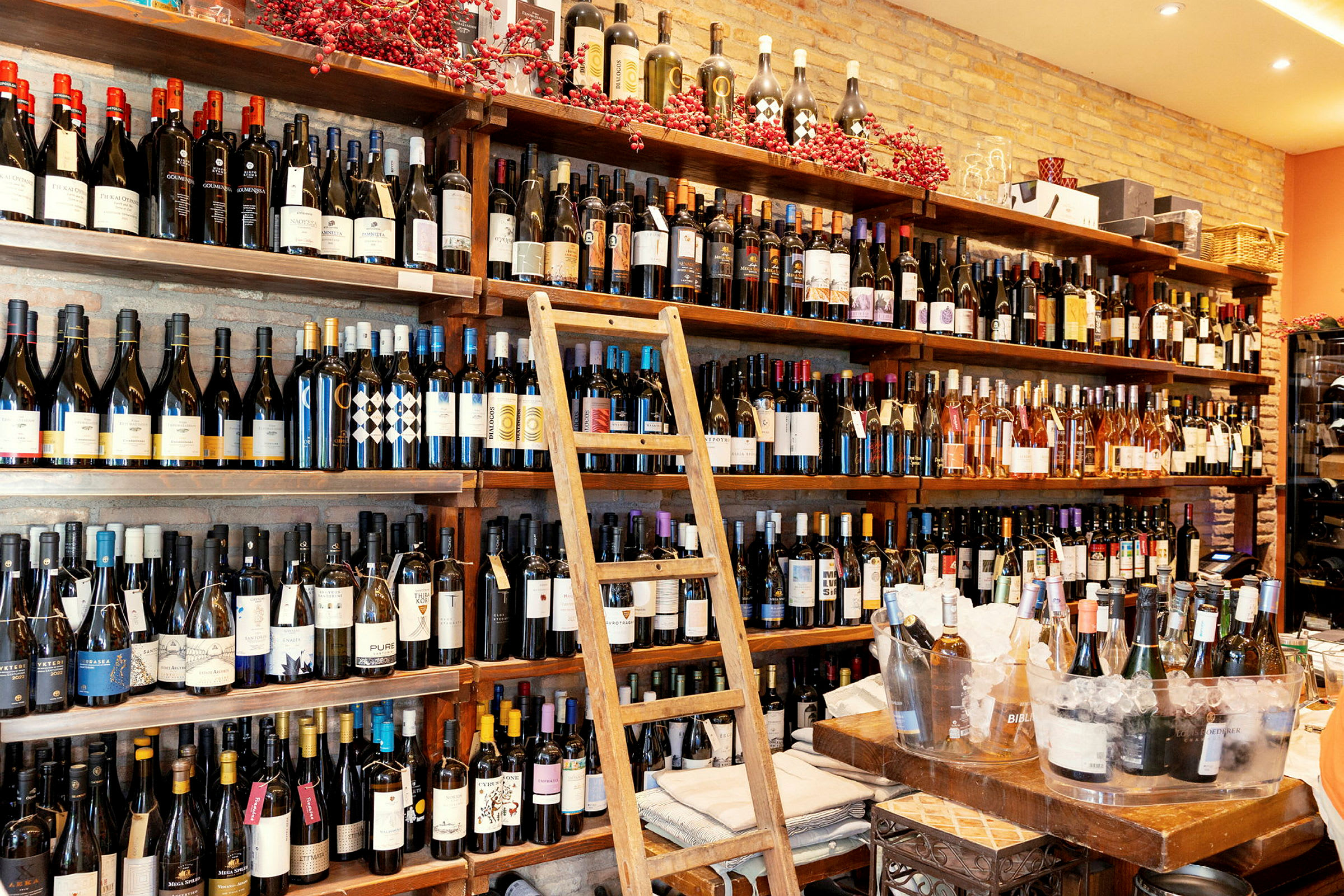 Hylla fylld med flaskor av vin och en trästege placerad framför. (AI-genererad text)