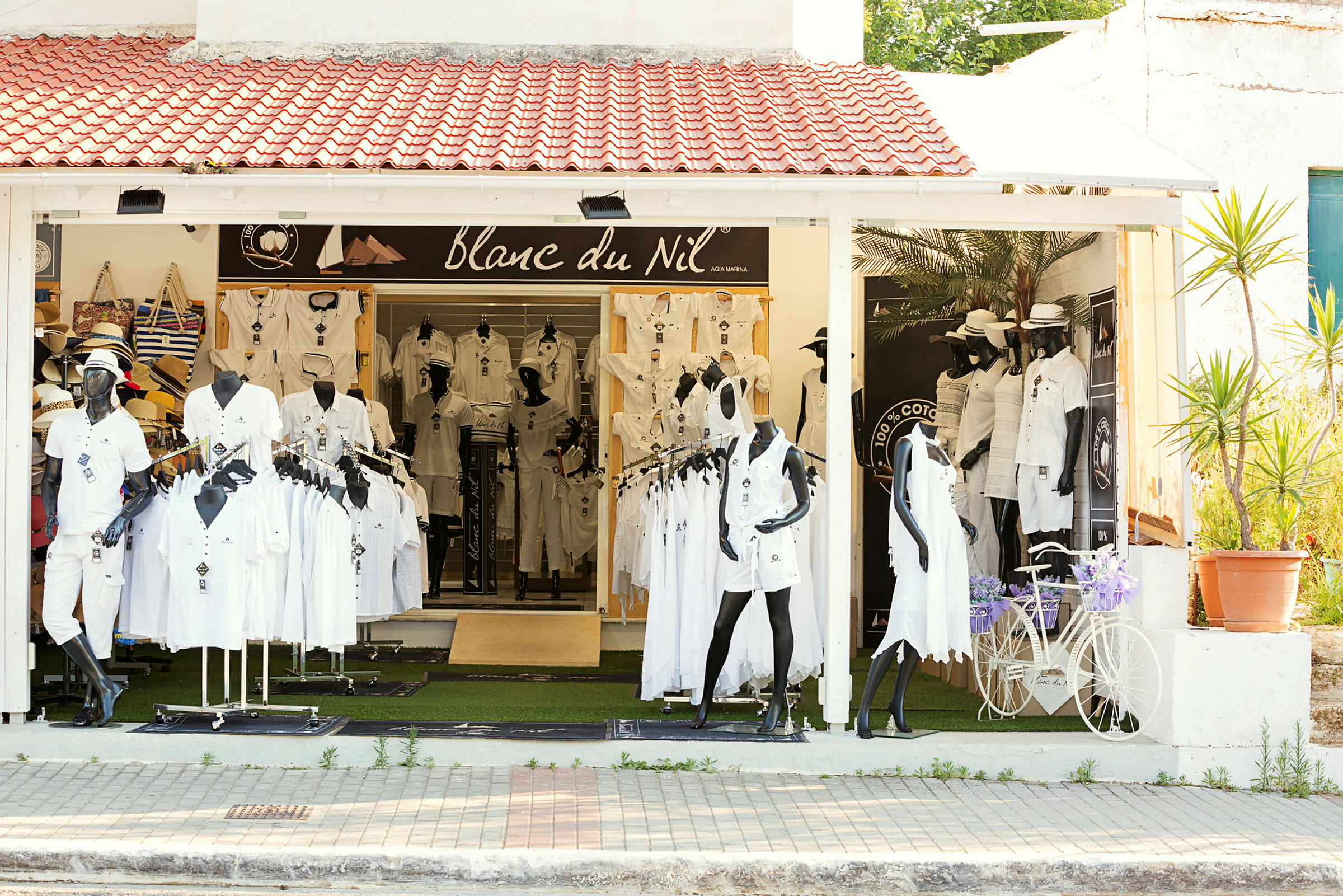 Butik med vita kläder på skyltdockor utanför. (AI-genererad text)