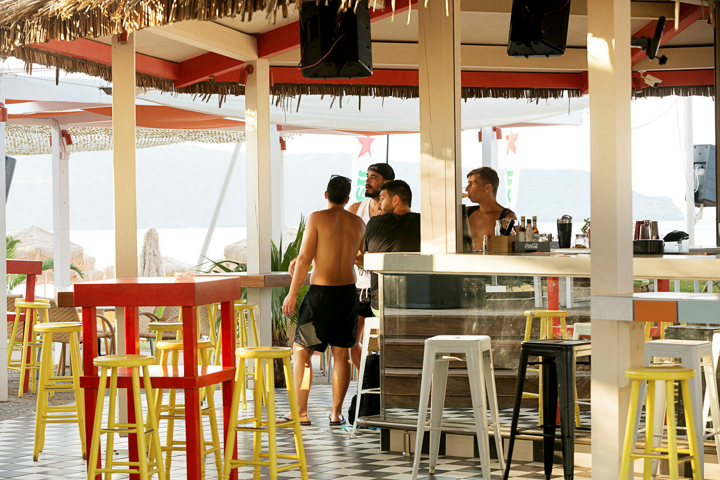 Ett utomhusområde med bar och färgglada stolar. (AI-genererad text)