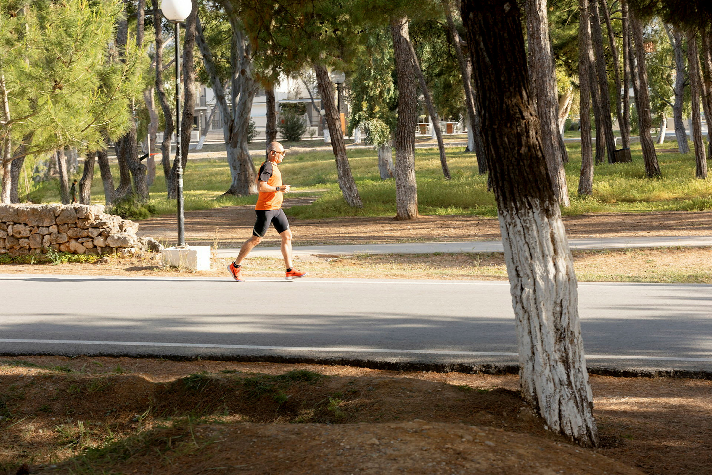 En person joggar på en väg omgiven av träd. (AI-genererad text)
