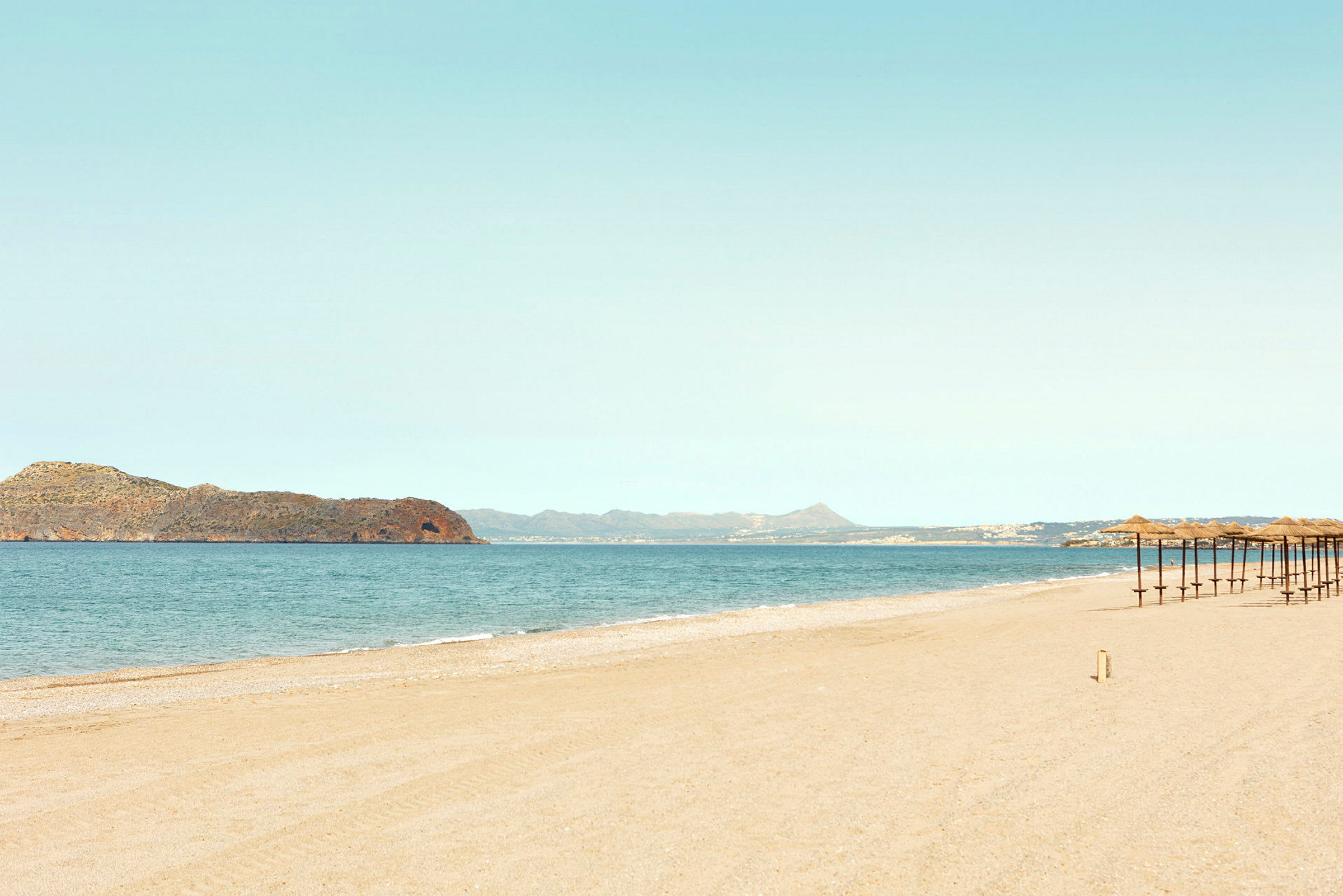 Strand med parasoller och hav i bakgrunden. (AI-genererad text)