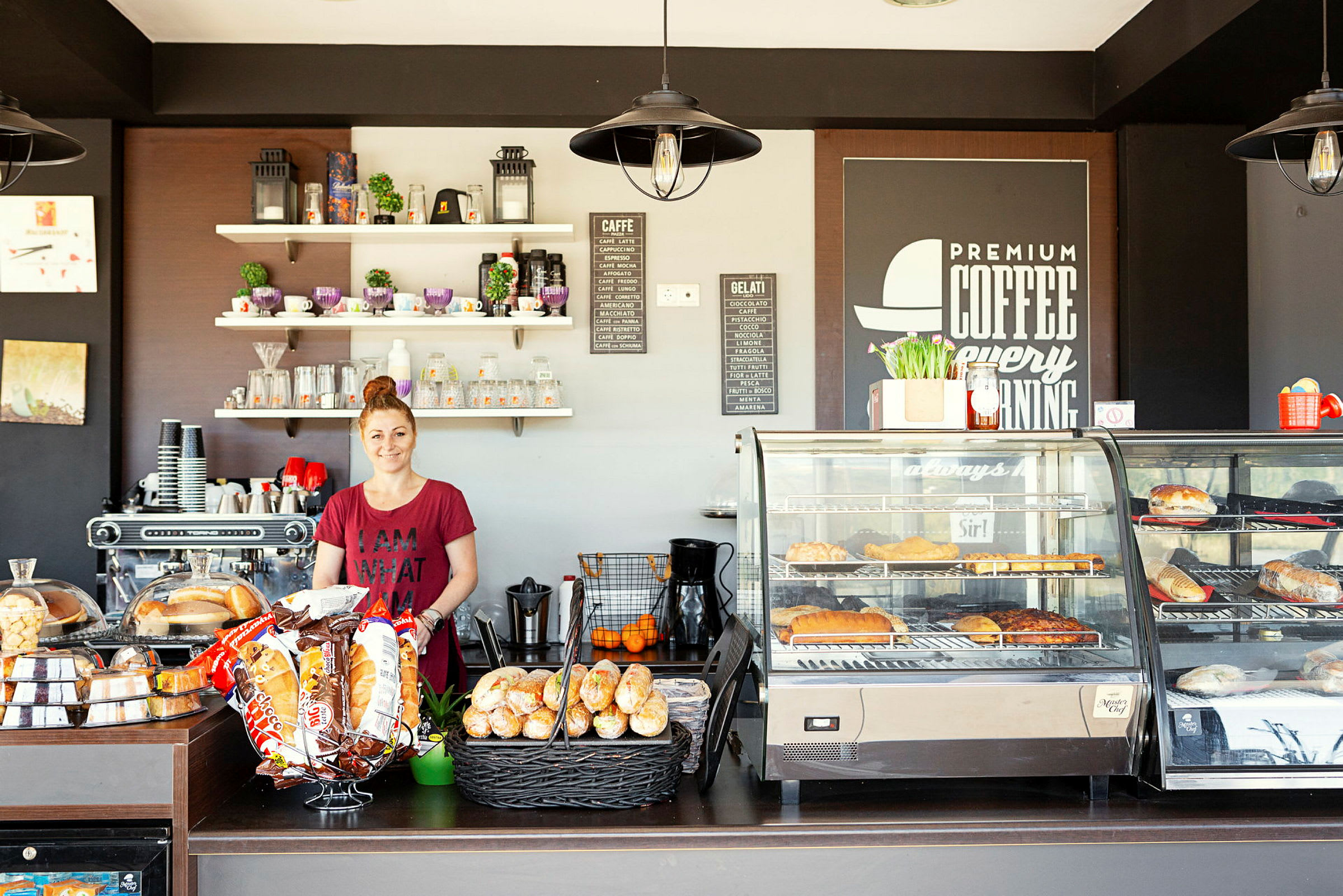 En serveringsdisk i ett café, med hyllor, kaffemaskin och kakor. (AI-genererad text)