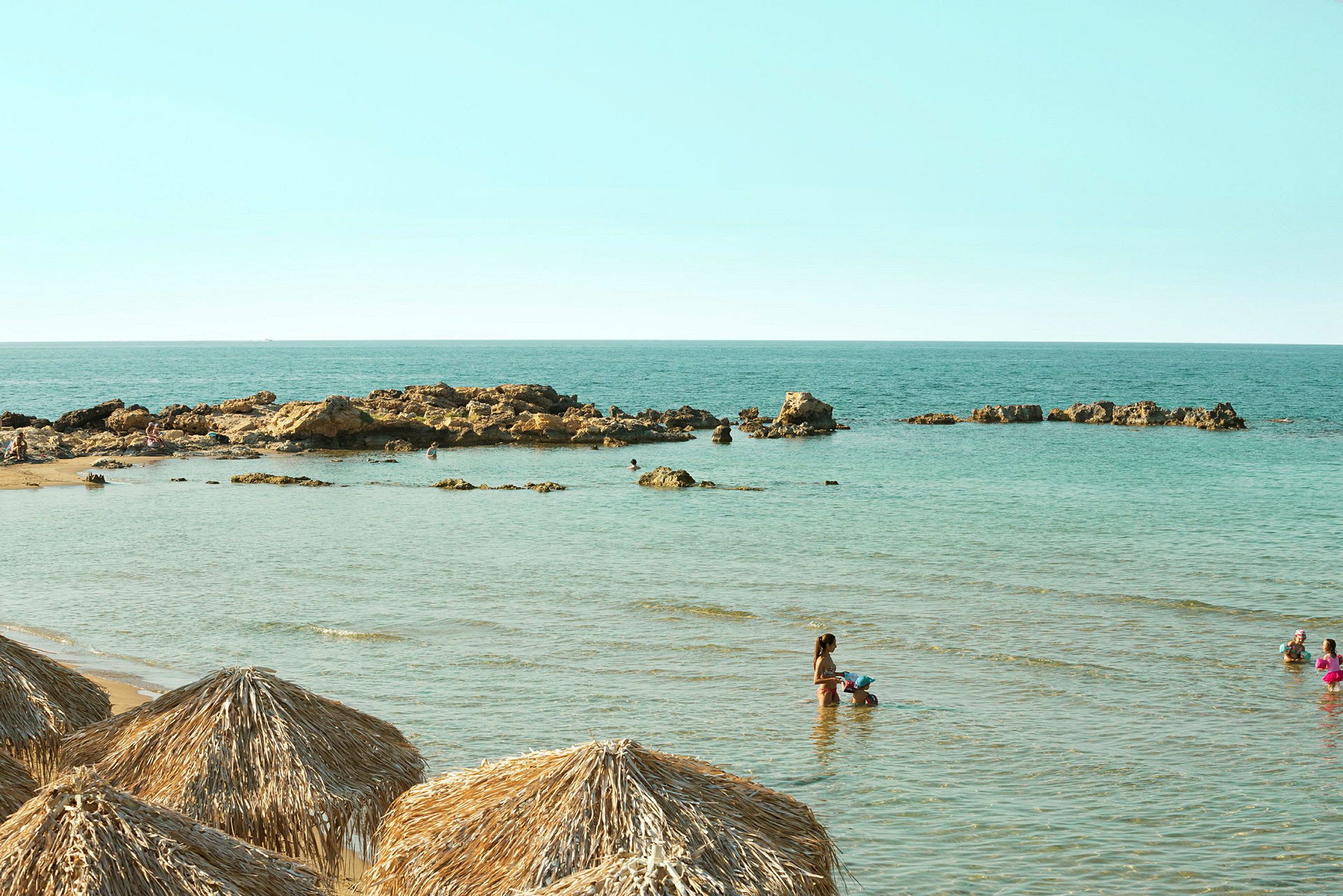 Strand med grunda vatten och stenformationer. (AI-genererad text)