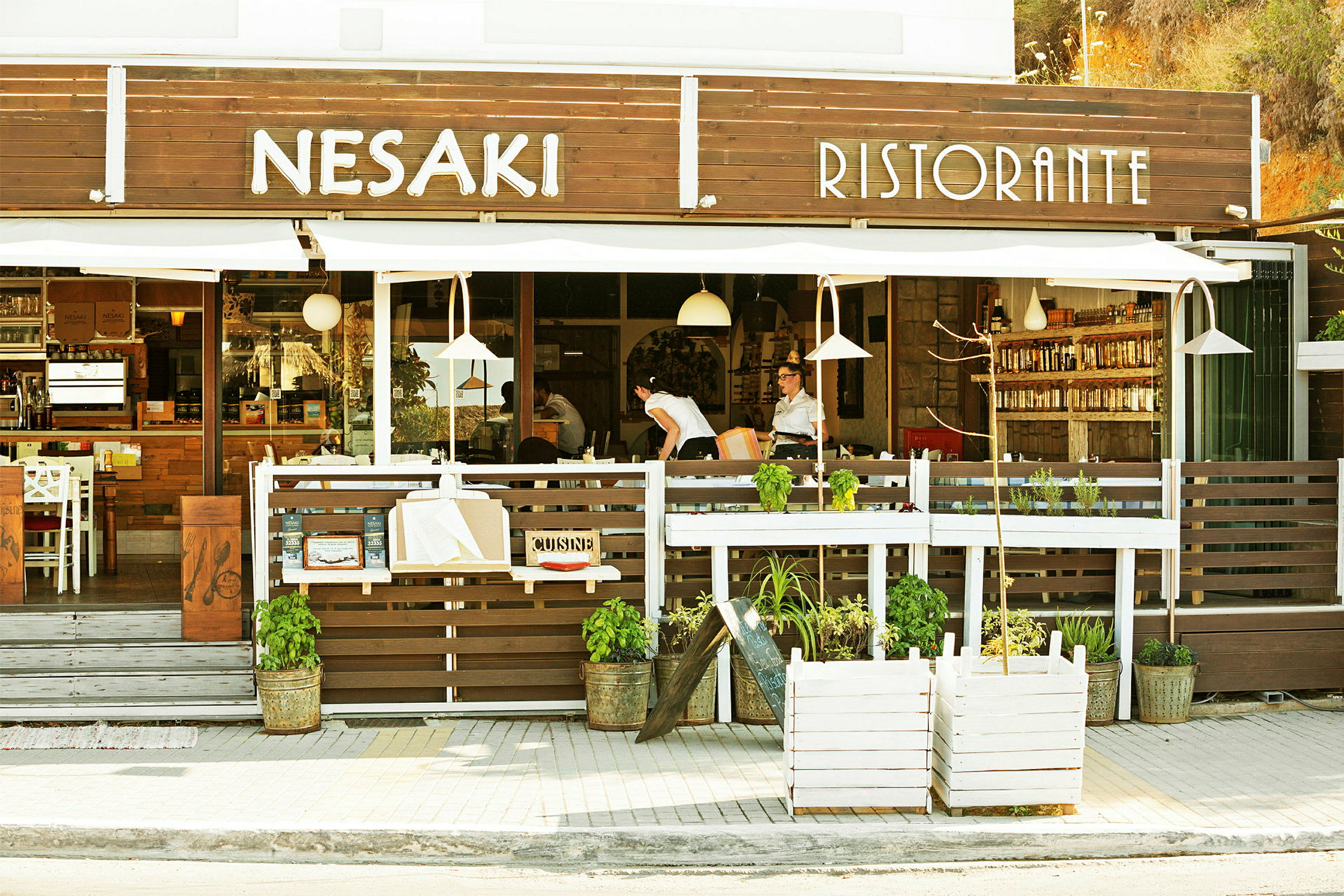 Bild av fasaden av en restaurang med texten "Nesaki Ristorante" över ingången och med uteservering. (AI-genererad text)