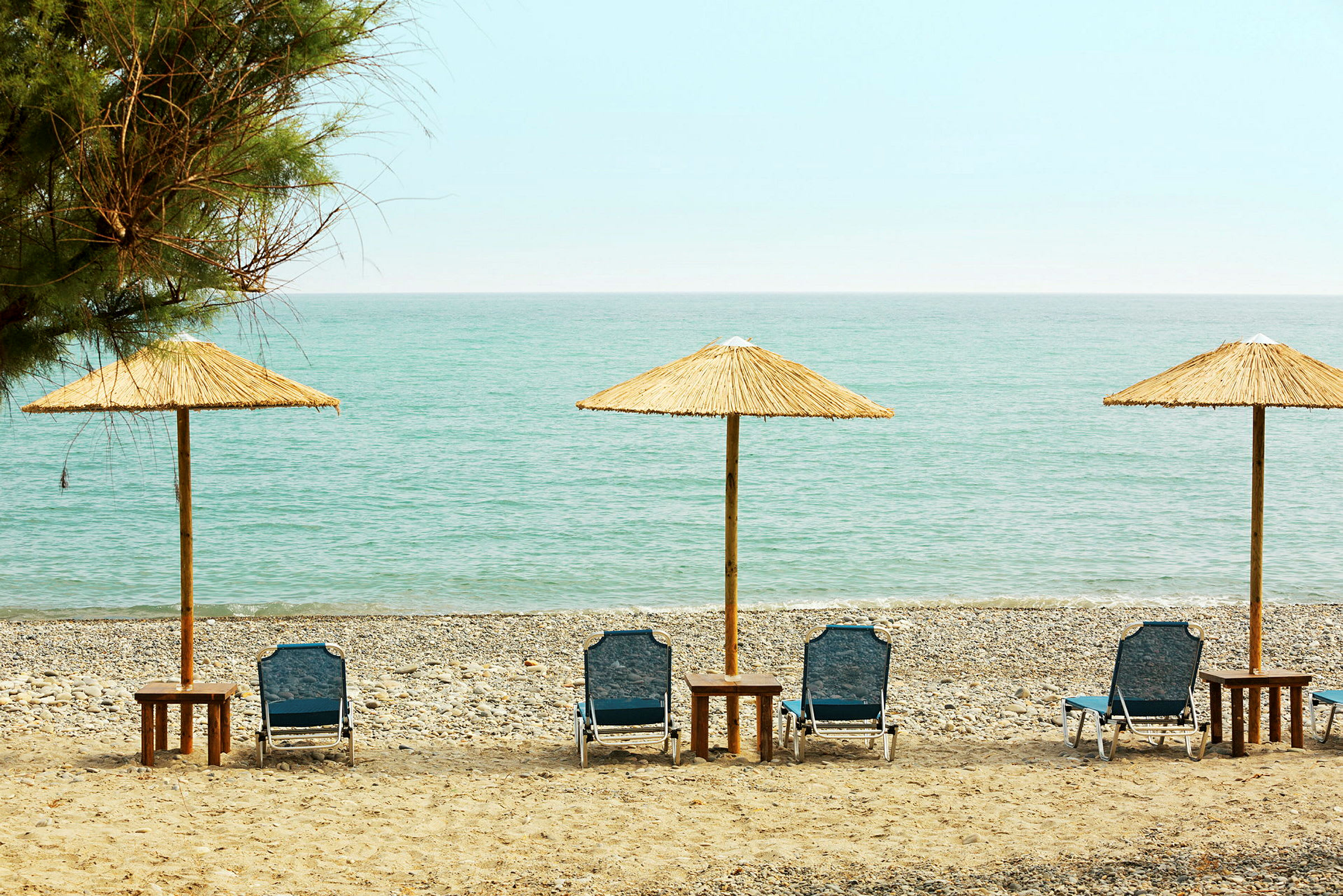 Liggstolar med parasoller vid en strand. (AI-genererad text)