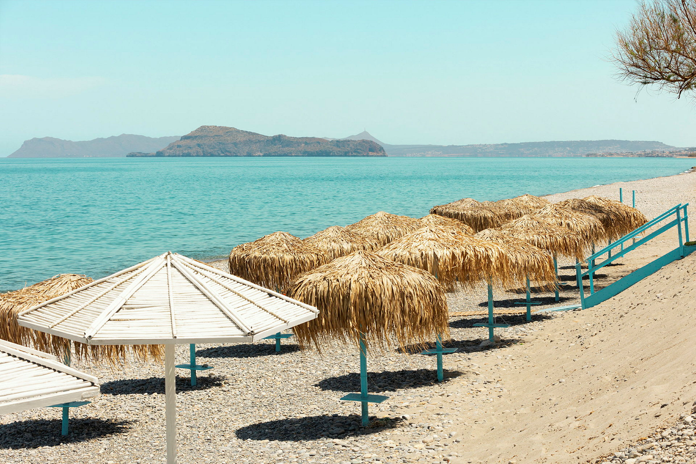Strand med parasoller och hav i bakgrunden. (AI-genererad text)