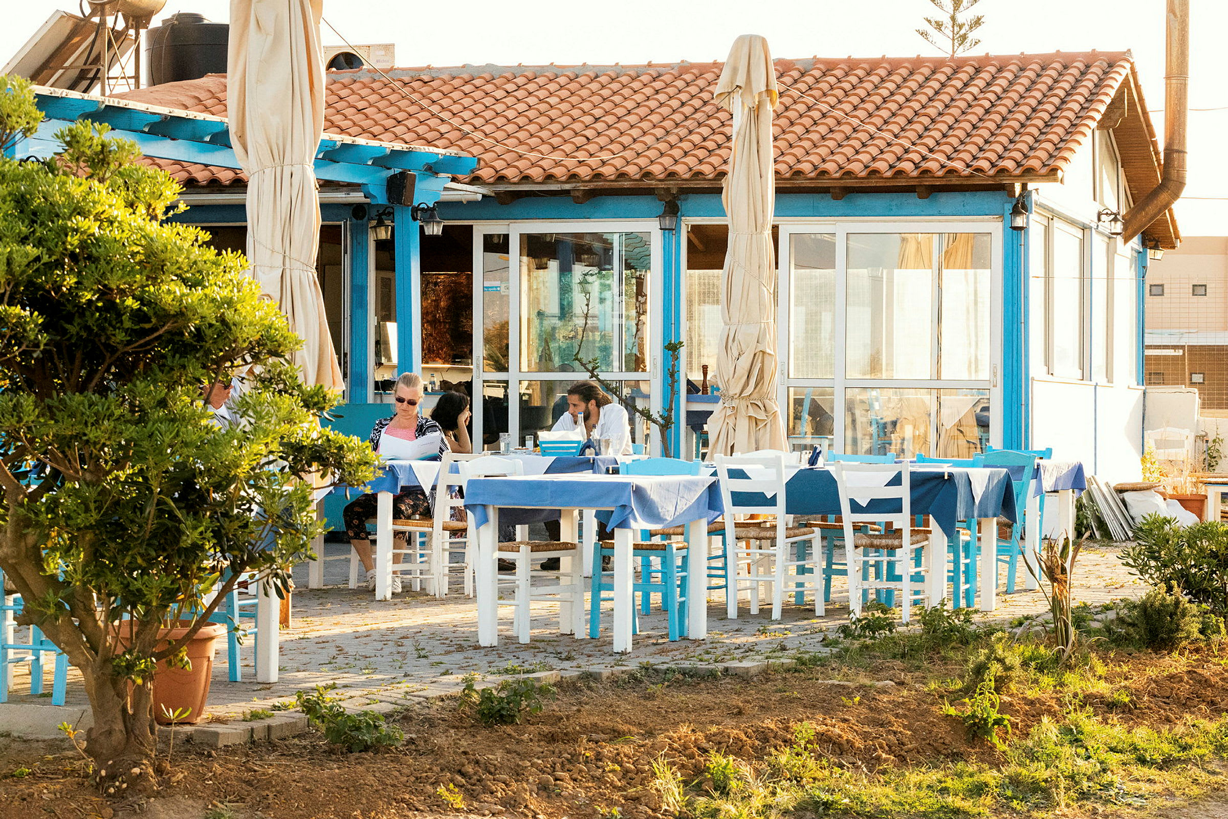En uteservering vid en restaurang med blå och vita detaljer. (AI-genererad text)