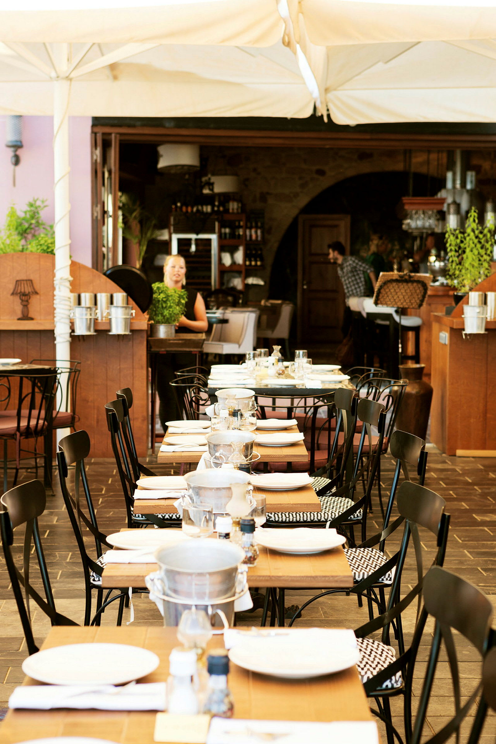 En restaurang med dukade bord utomhus under ett tält. (AI-genererad text)