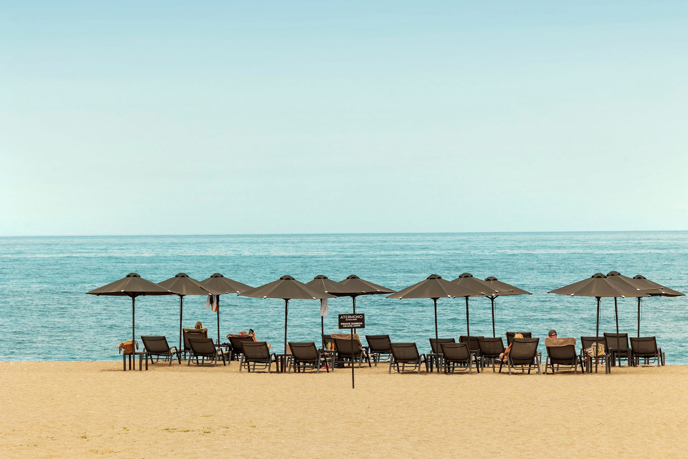 Strand med solstolar och parasoller vid havet. (AI-genererad text)