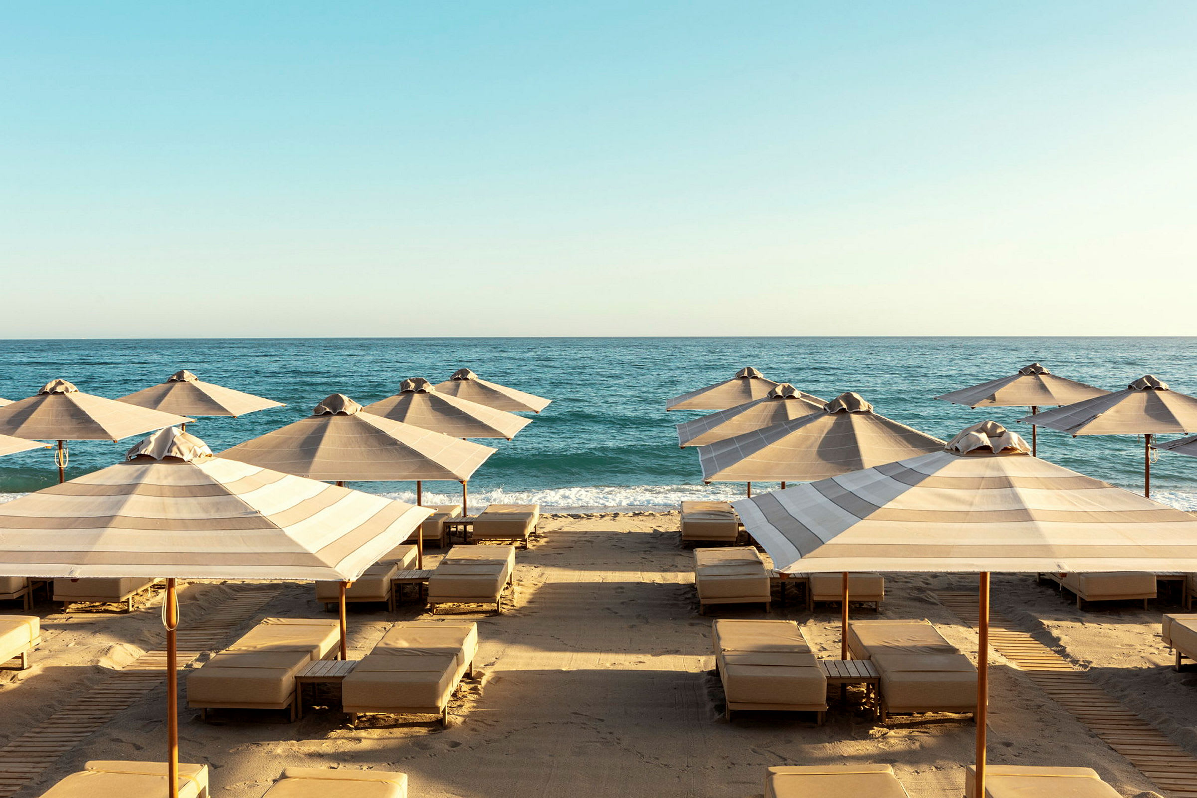 Strand med solstolar och parasoller vid havet. (AI-genererad text)
