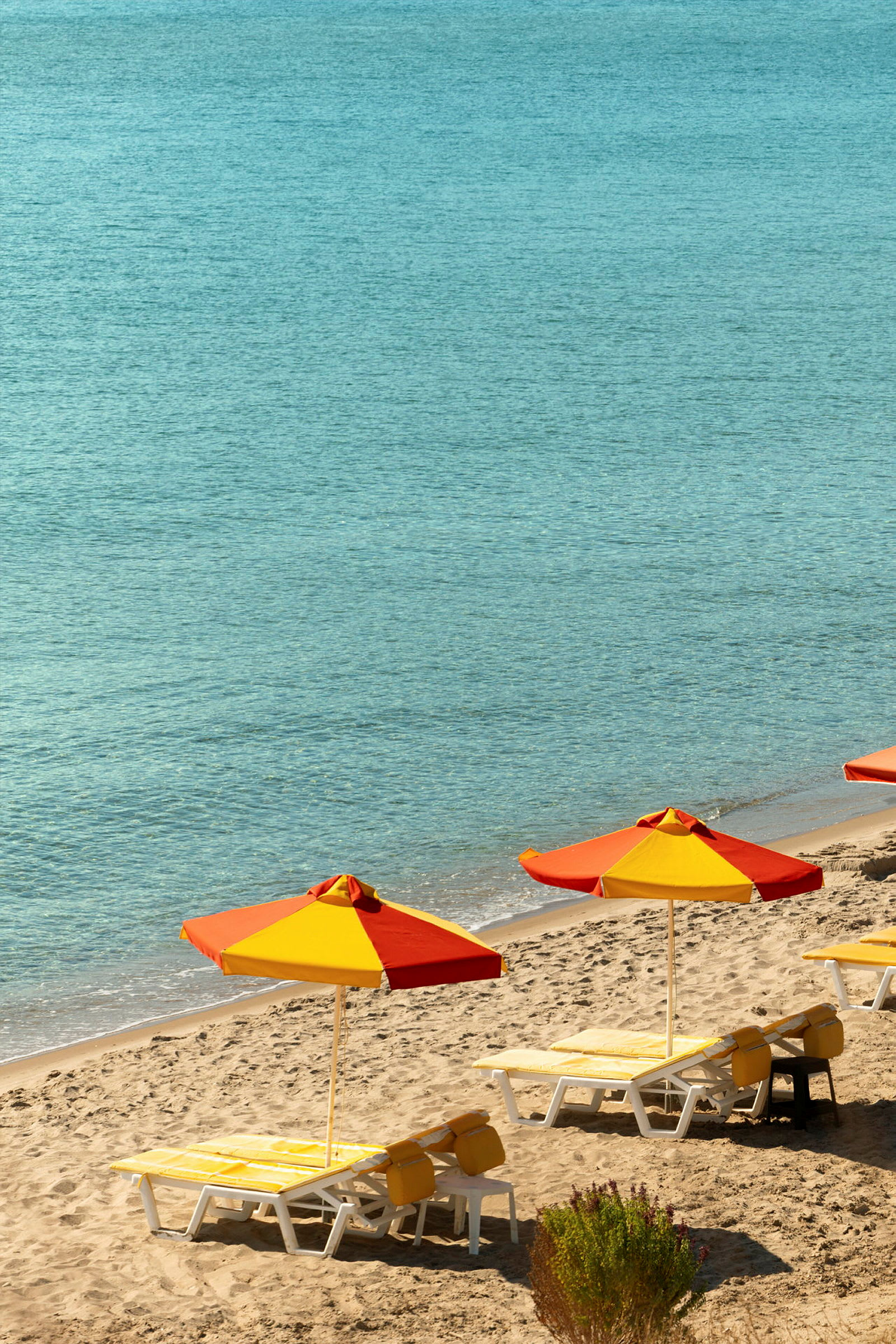 Strand med solparasoller och solstolar. (AI-genererad text)