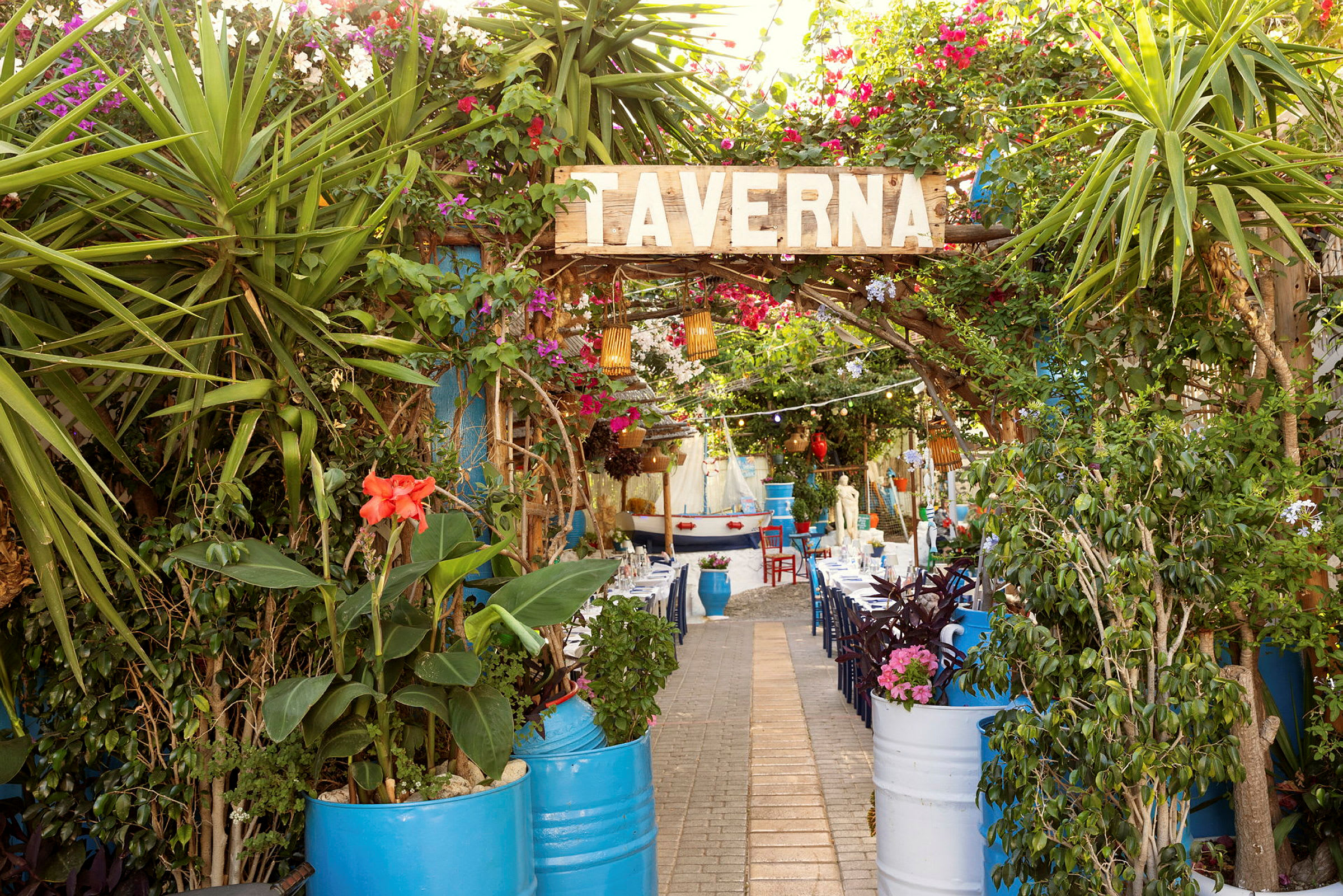 Entré till en taverna med grönska och färgglada blommor. (AI-genererad text)