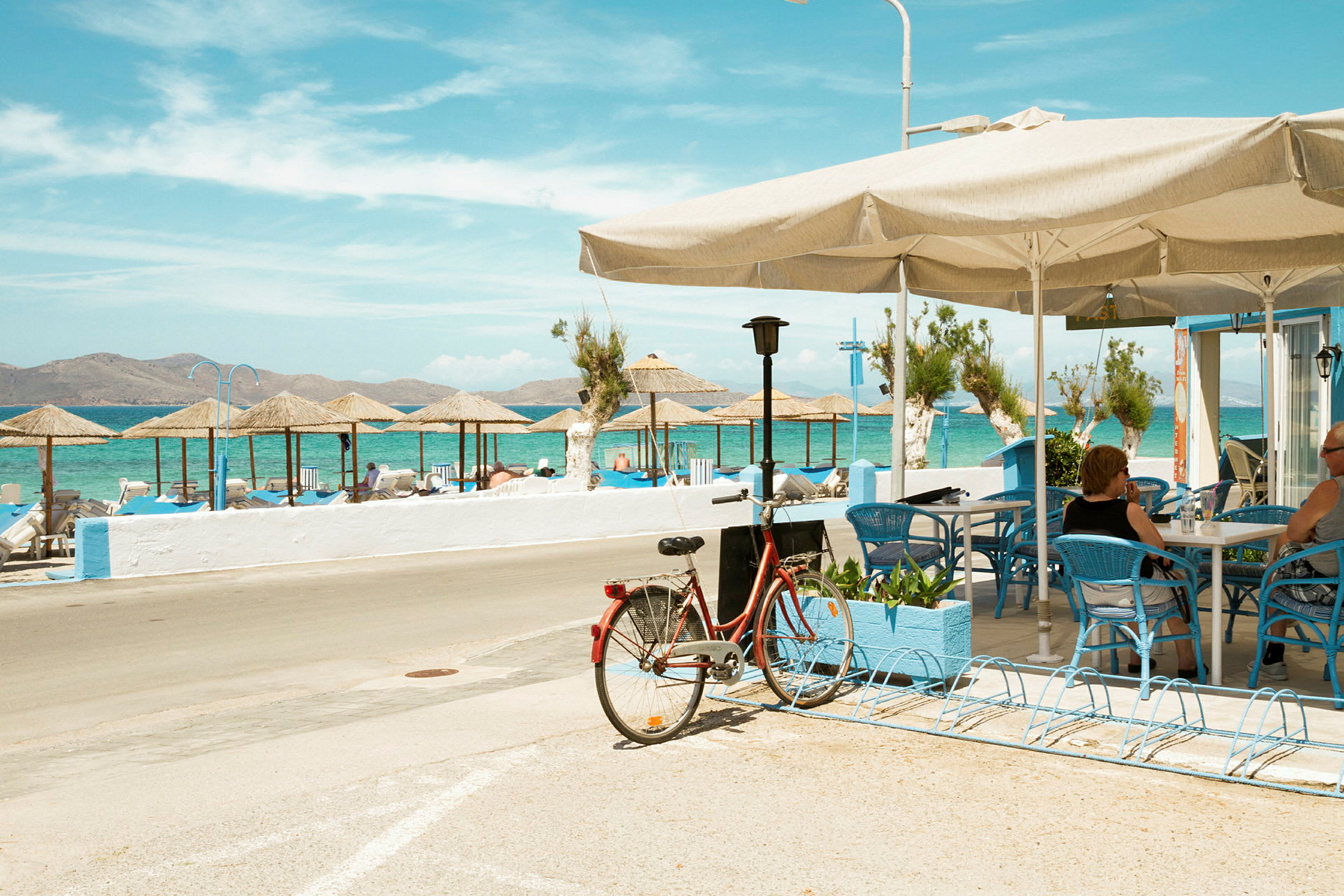 Cykel parkerad vid ett café med utsikt över stranden och havet. (AI-genererad text)