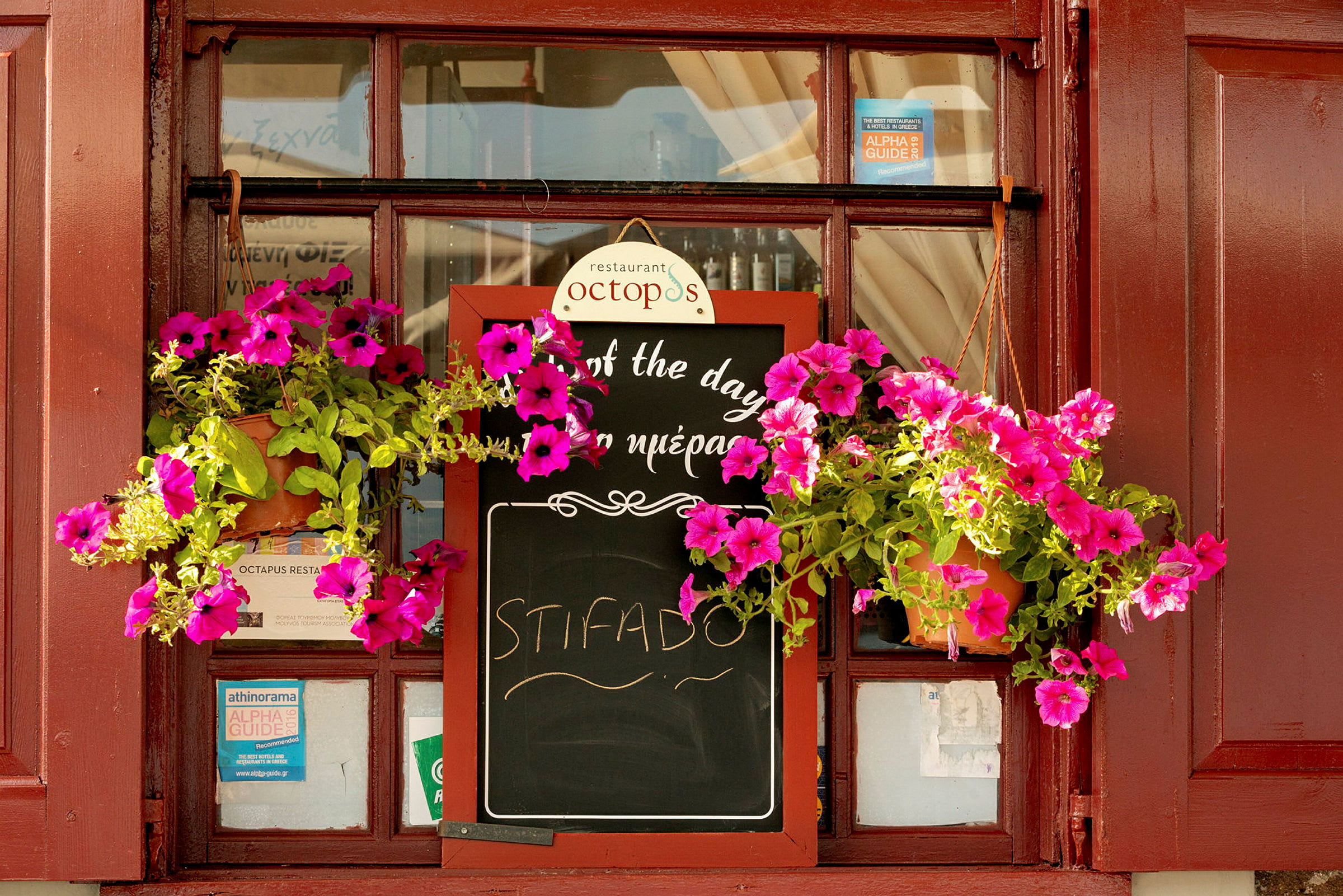 En restaurangskylt med blommor som hänger runt den. (AI-genererad text)