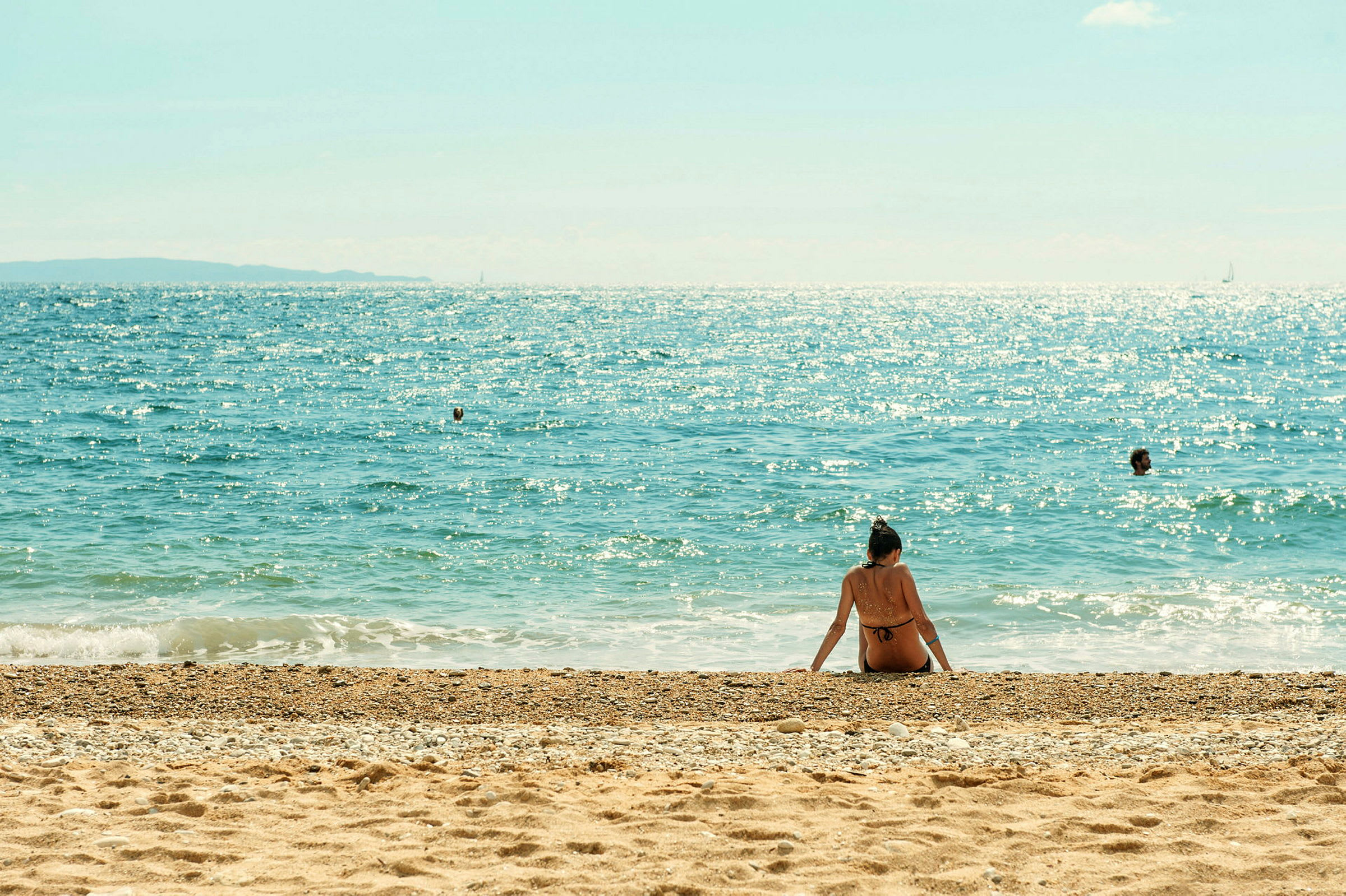 En person sitter på stranden med havet i bakgrunden. (AI-genererad text)