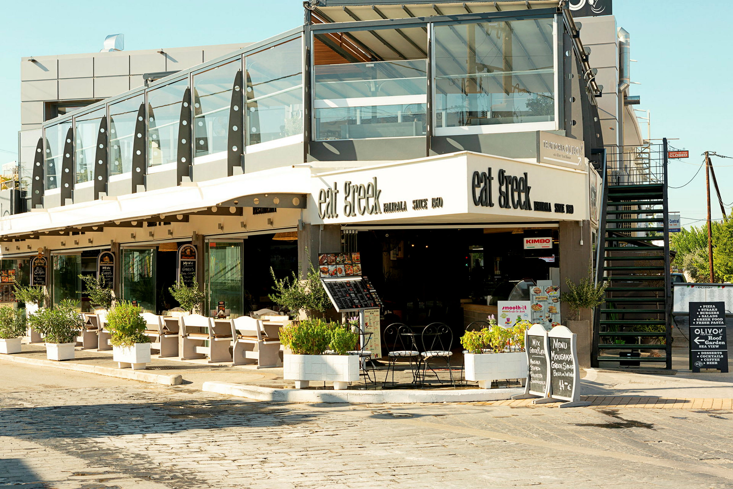 Restaurang med uteservering och skyltar som visar menyn. (AI-genererad text)