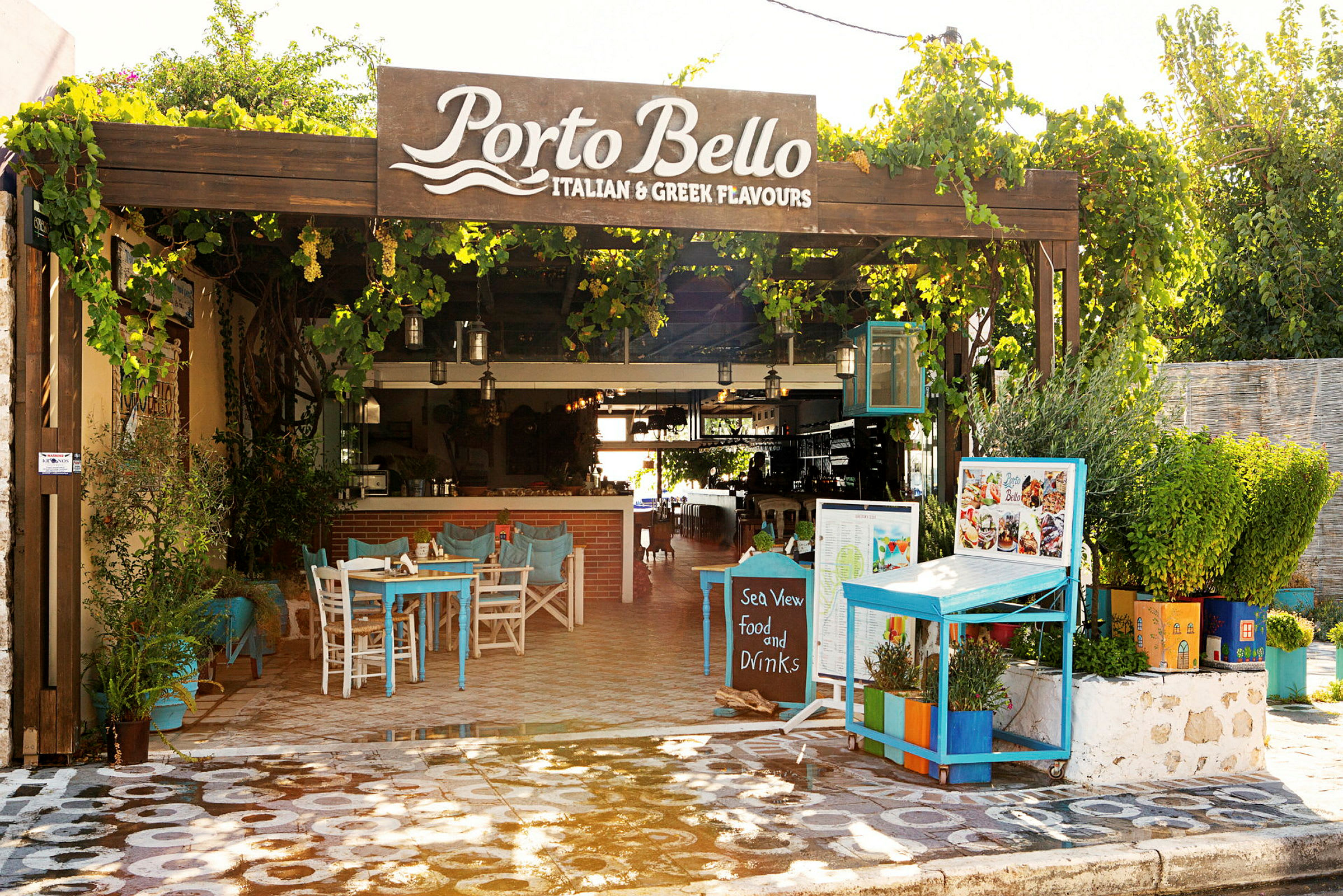Bild av en utomhusrestaurang kallad Porto Bello med bord och växter. (AI-genererad text)