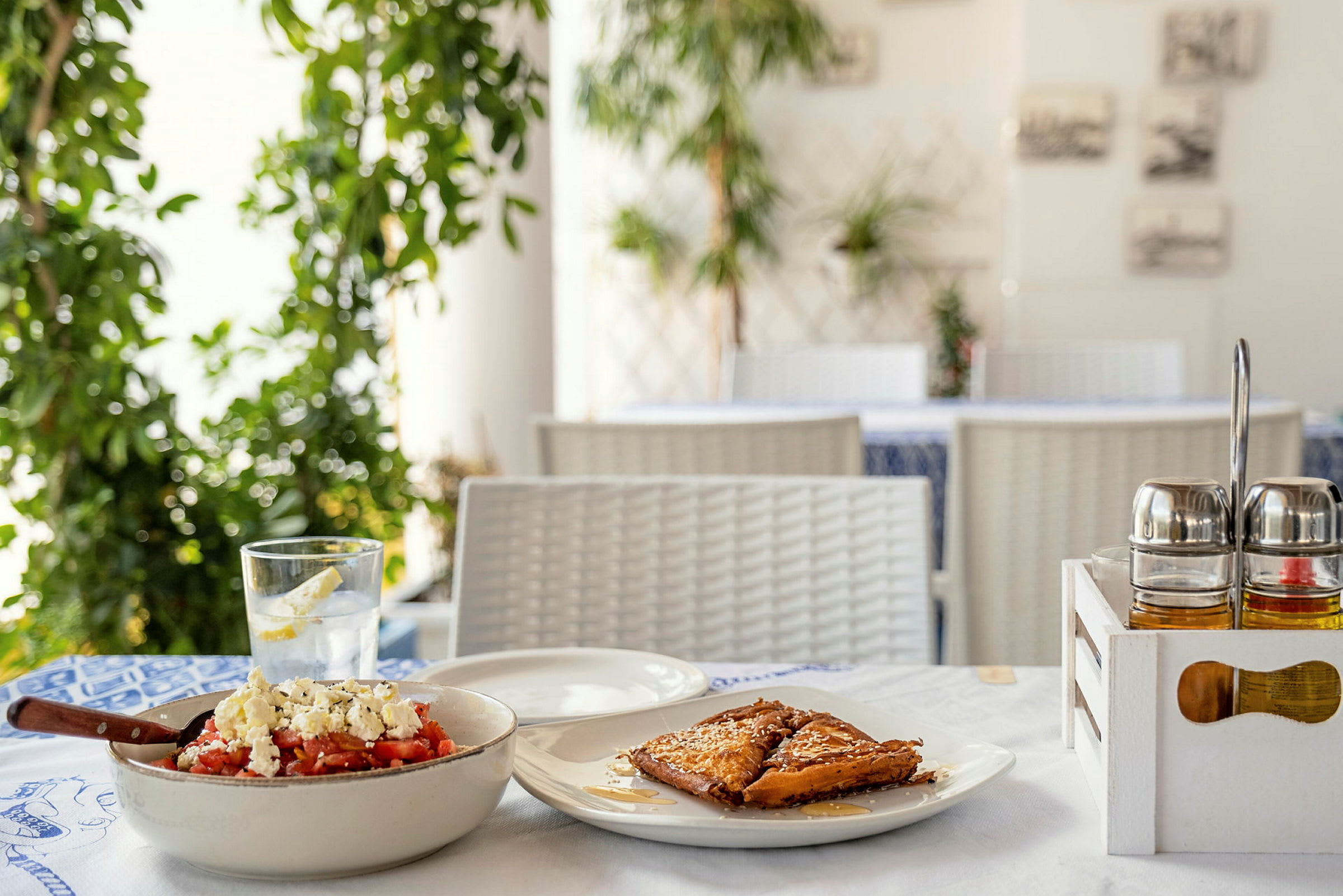 En närbild av en restaurangbord med en traditionell grekisk rätt och efterrätt. (AI-genererad text)
