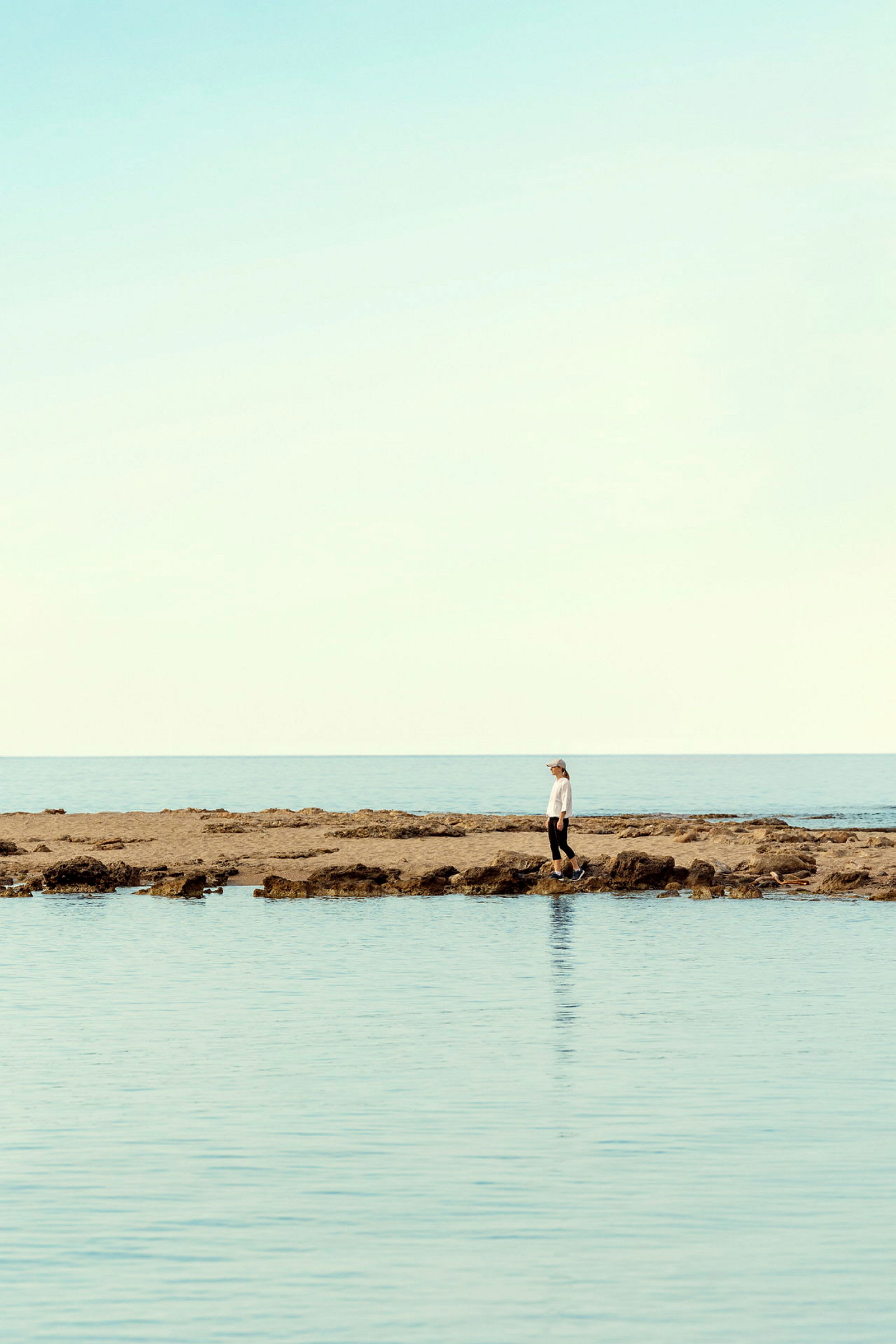 Person står på klippig strand vid havet. (AI-genererad text)